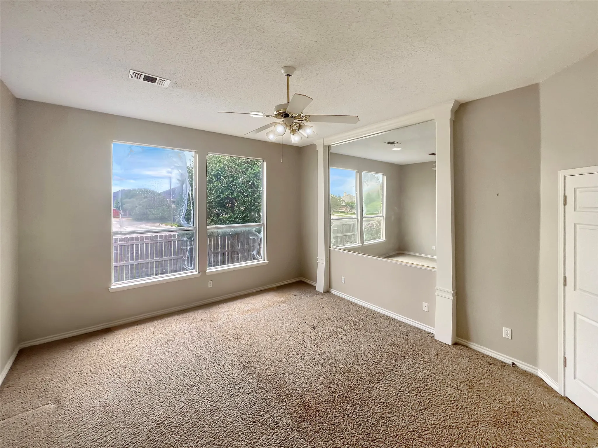 Carpeted room featuring a single window and crown molding with a decorative border