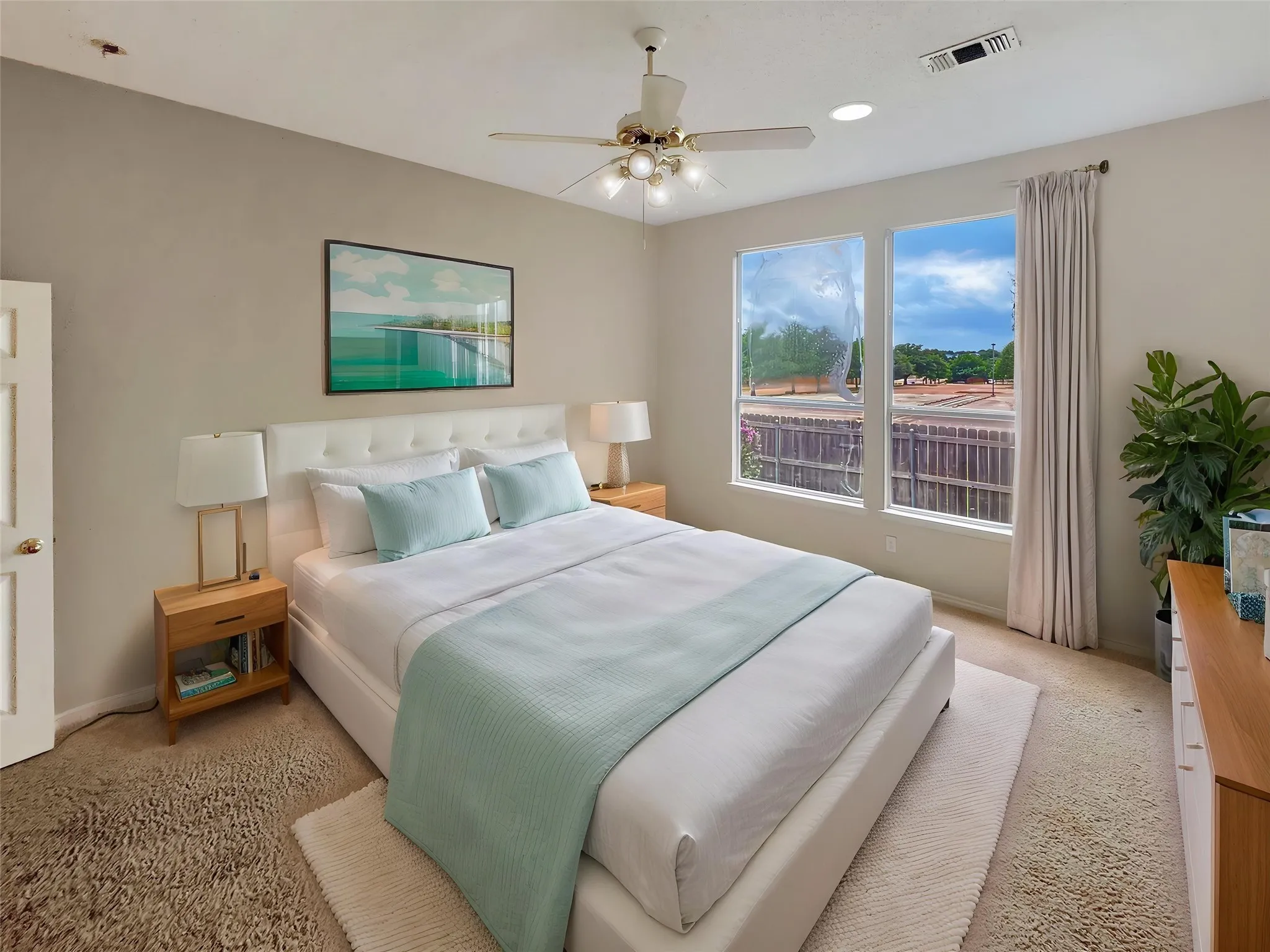 Virtually staged -Bedroom featuring a neutral color palette, twin windows, a ceiling fan with integrated lighting, and recessed ceiling lights