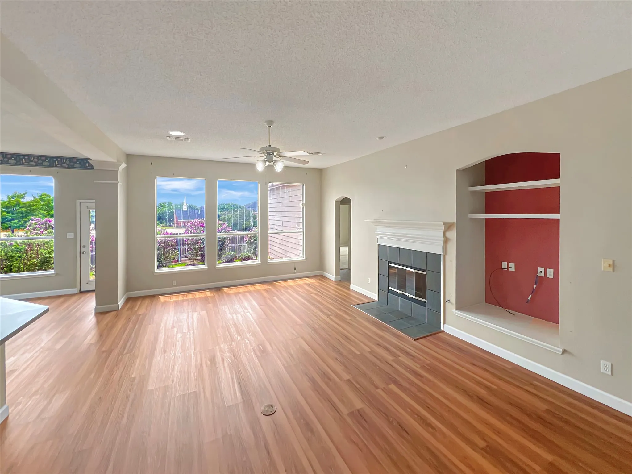 Spacious interior featuring wood-finish flooring and multiple windows