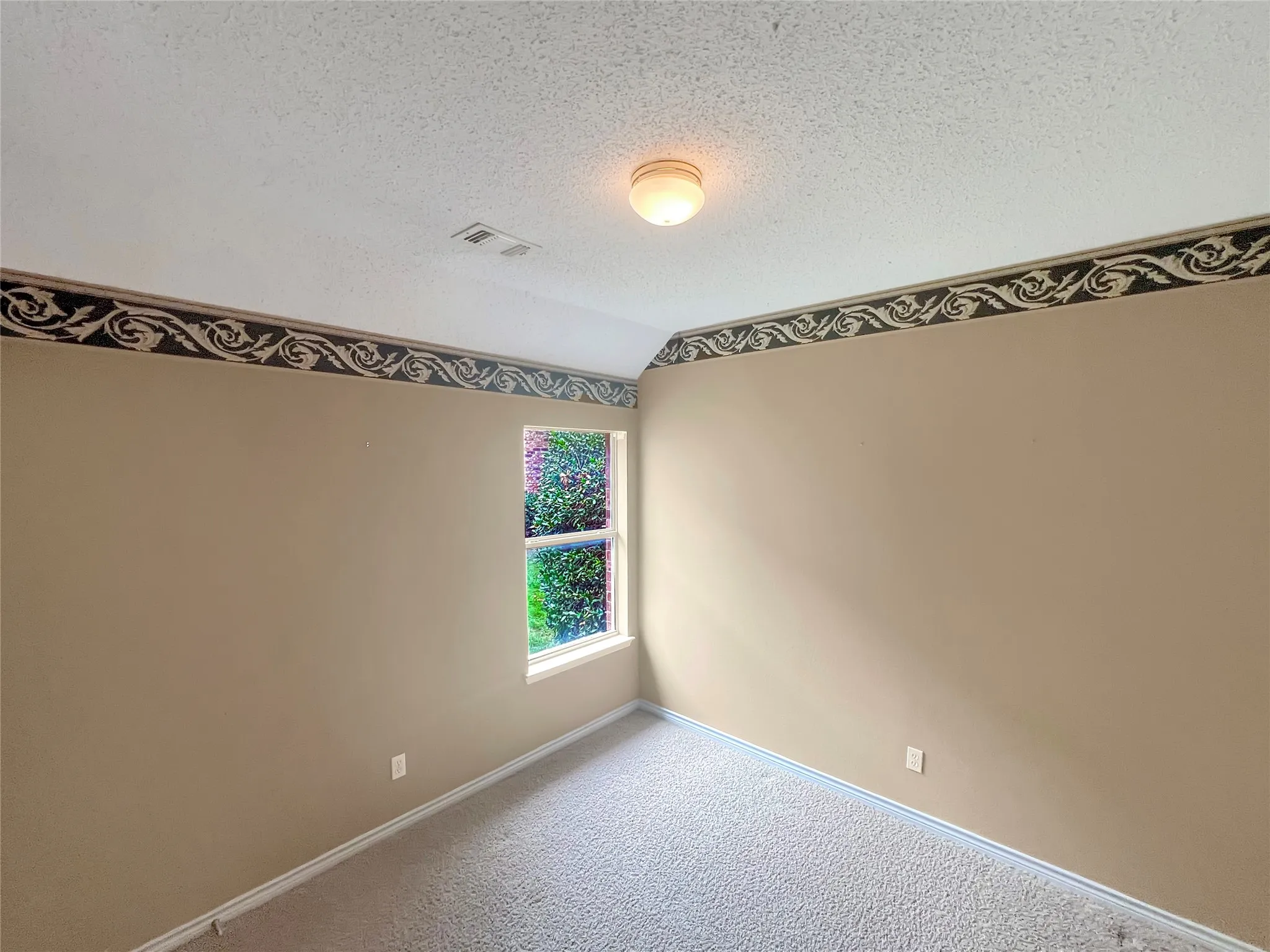 Virtually staged -Carpeted room featuring a large window, a wall-mounted fixture, and a built-in upholstered headboard