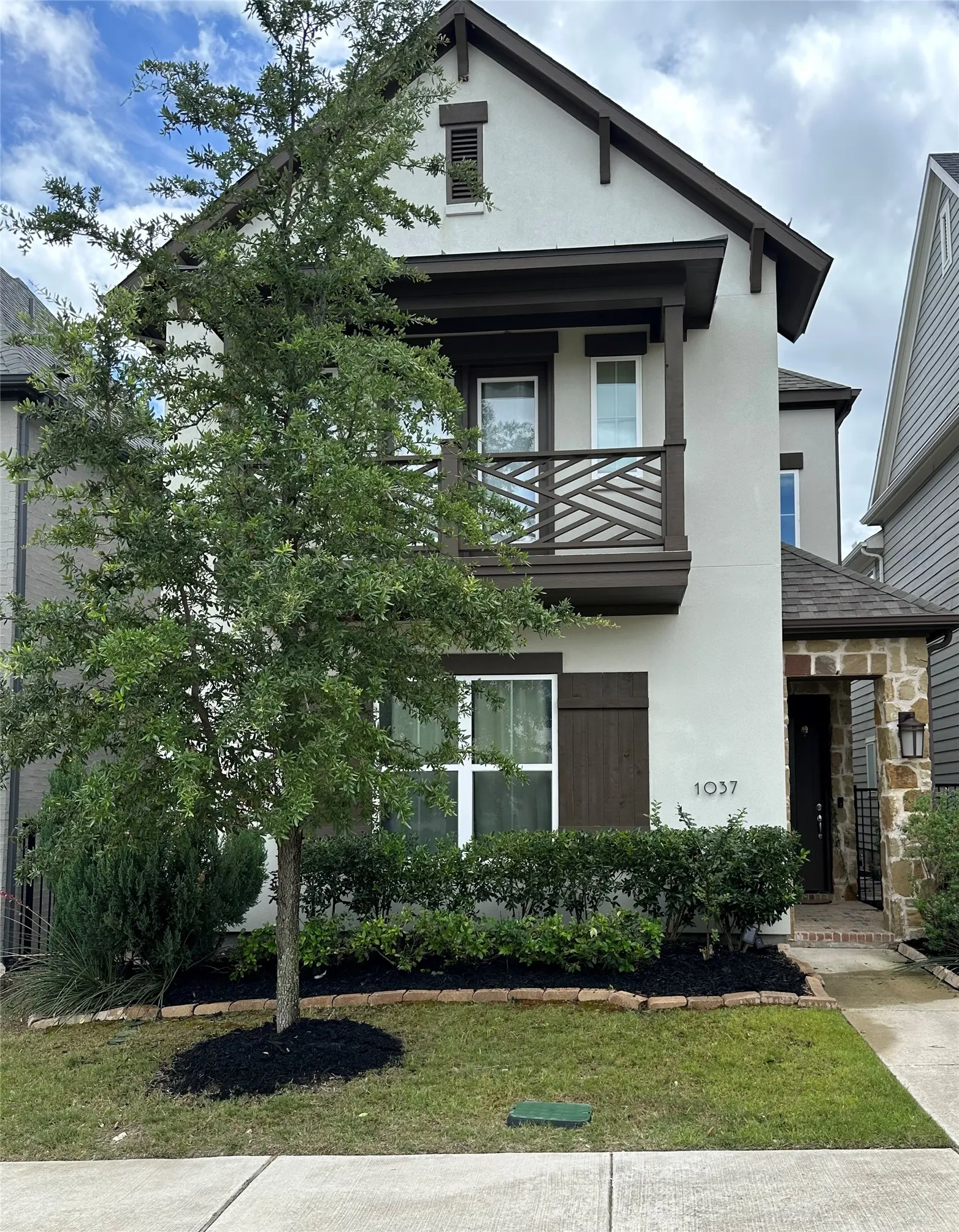 Two-story stucco facade featuring dark trim accents
