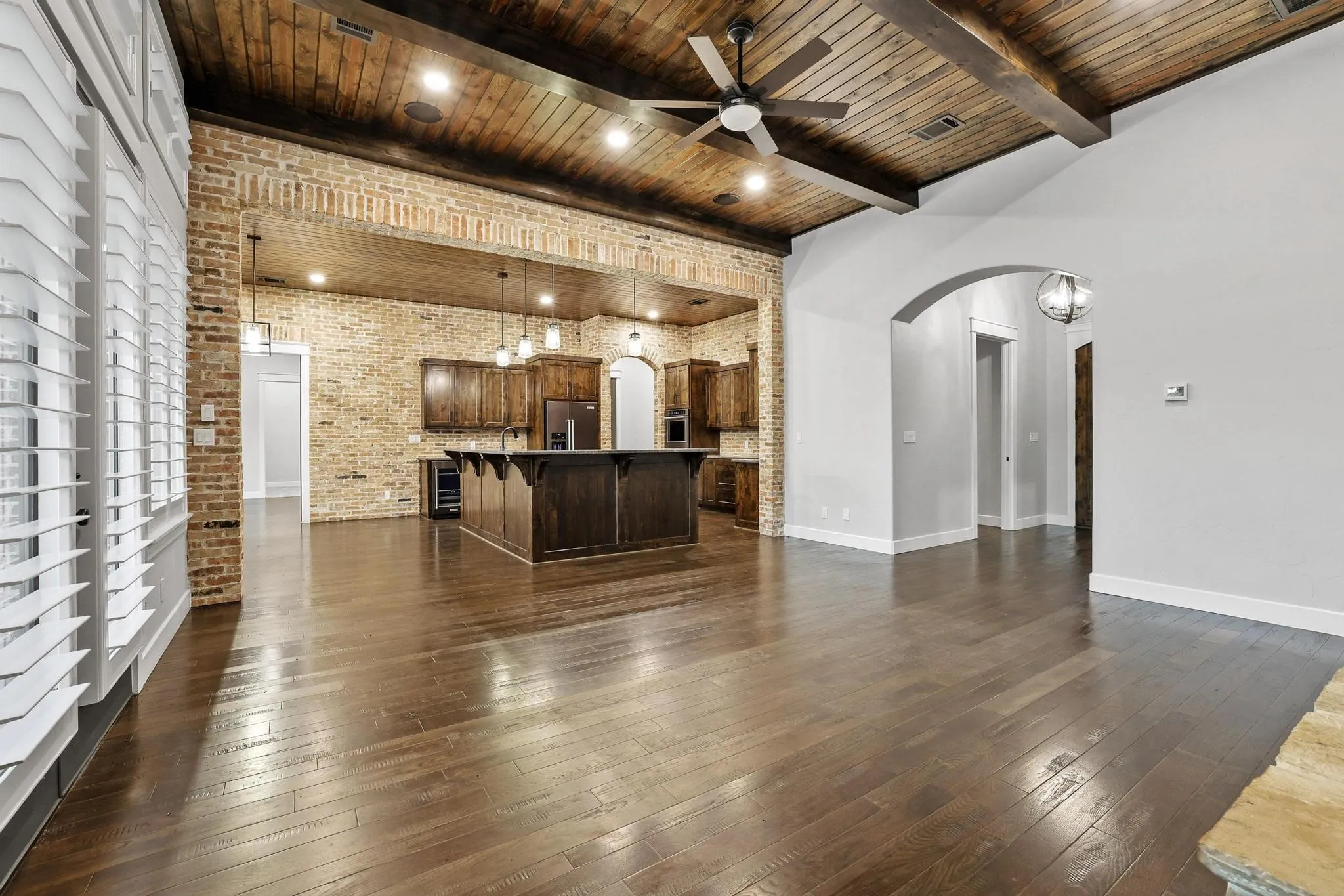 Vaulted wood-plank ceiling with exposed beams and recessed lighting