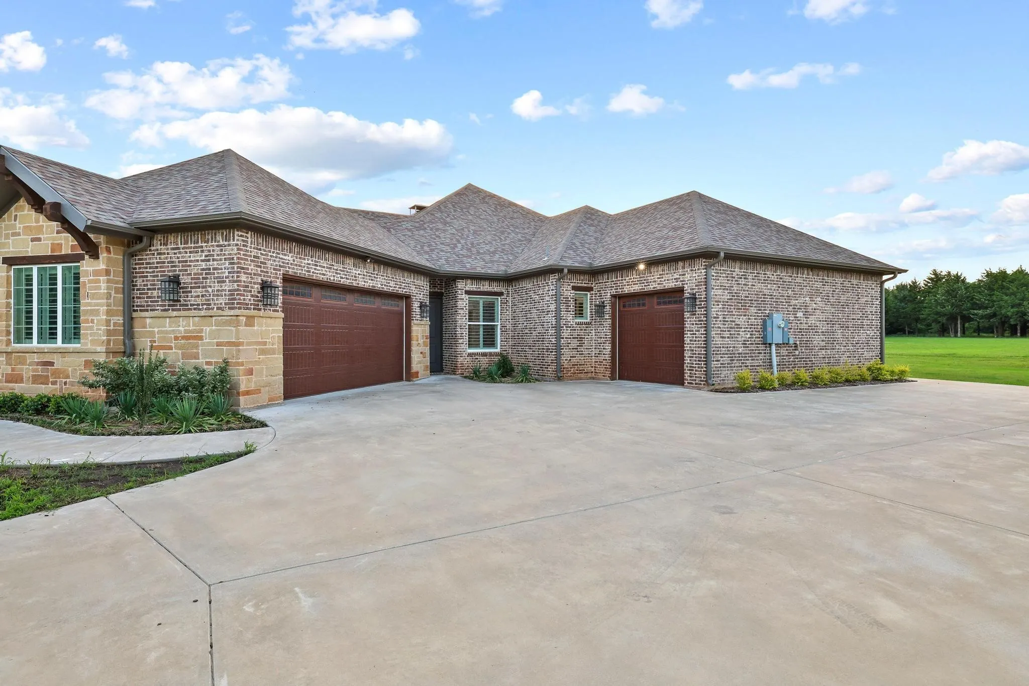Expansive concrete driveway leading to a multi-car garage