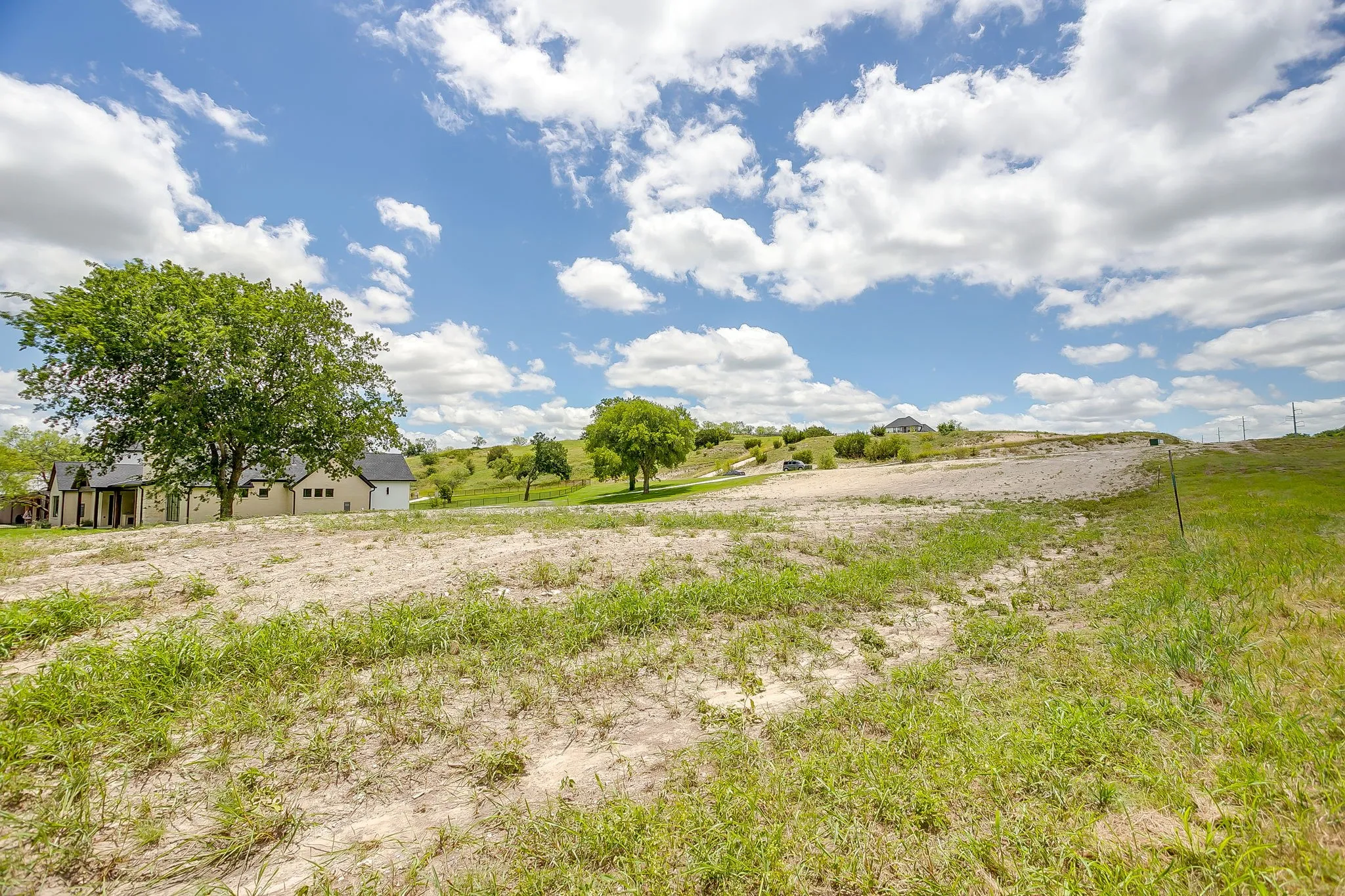 Expansive undeveloped lot featuring varied topography and patches of natural grasses