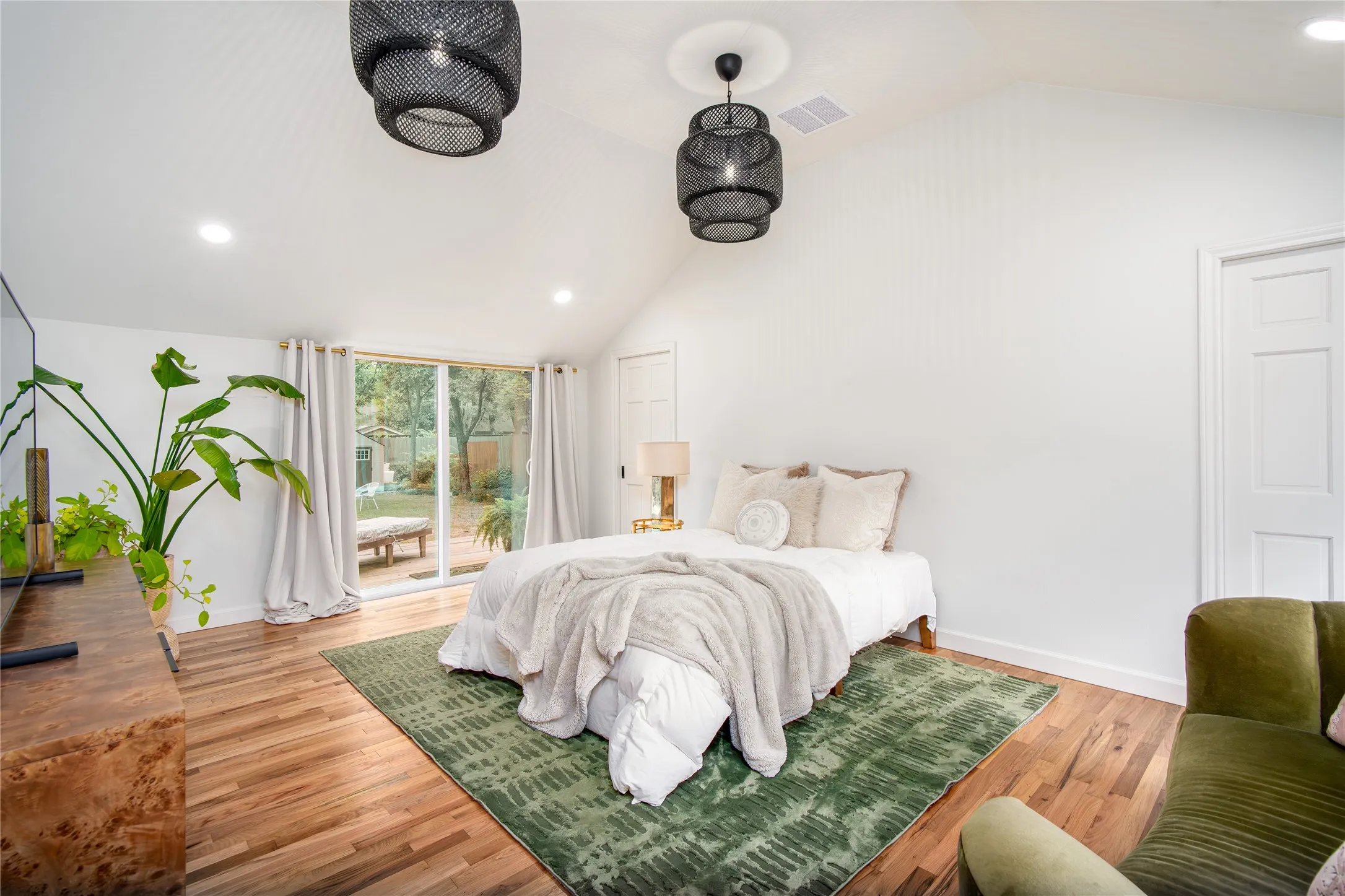 Primary Suite includes vaulted ceiling en suite bath and doors leading to deck and yard