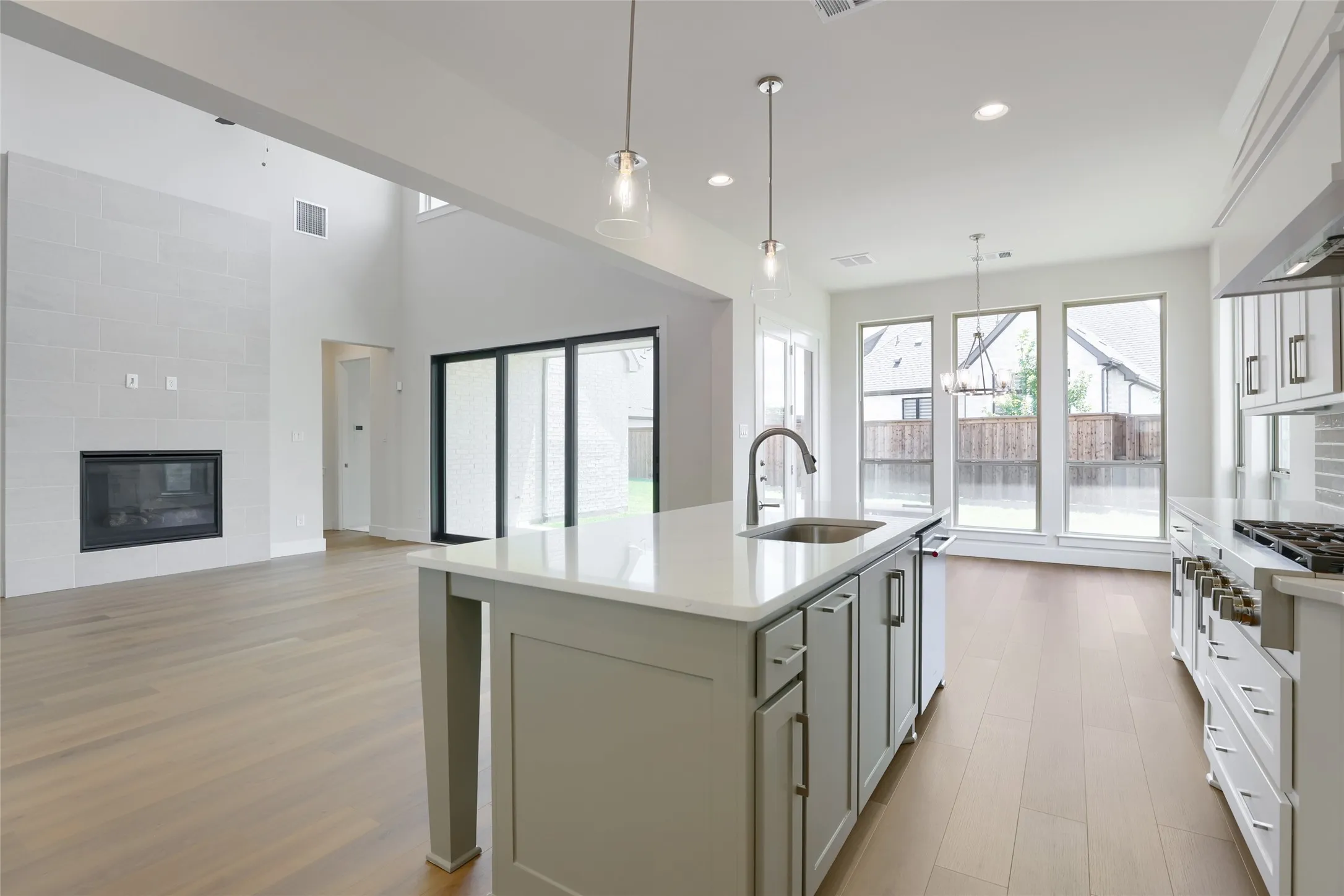Kitchen island featuring a stainless steel sink and pendant lighting