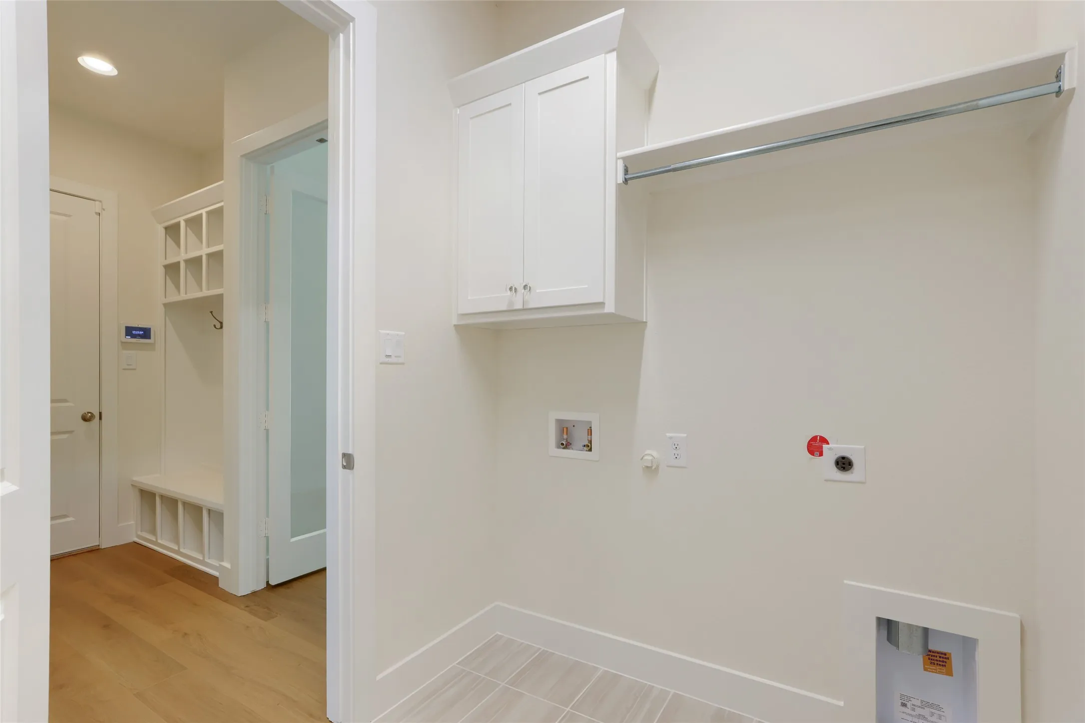 Utility space featuring white cabinetry, built-in shelving, and a hanging rod