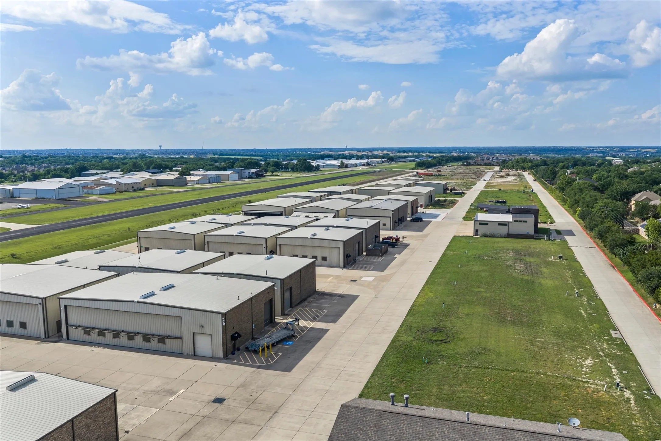 Aerial view of hangars, taxiway & airport.