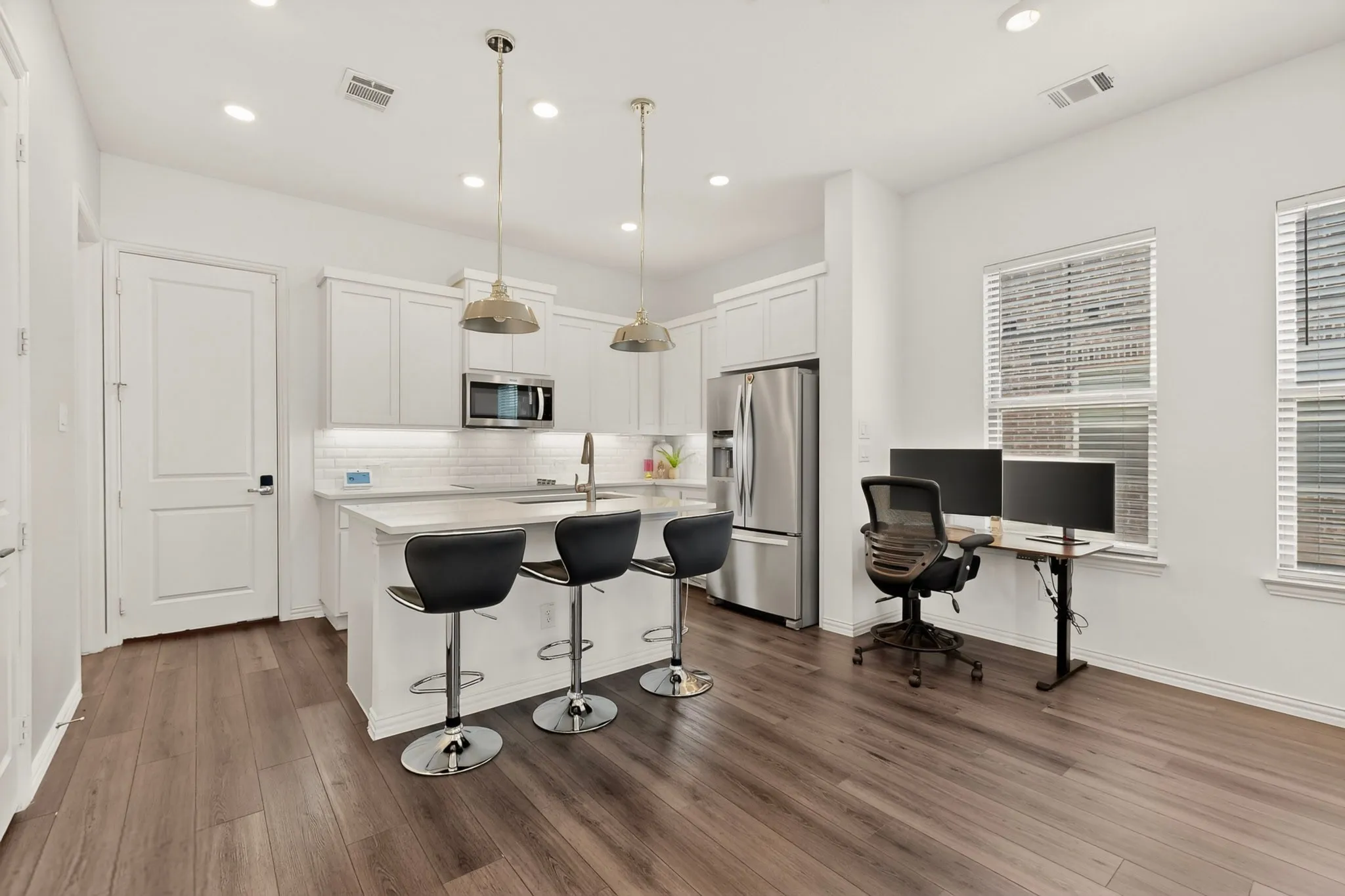 Modern kitchen with white cabinets, stainless steel appliances, and a kitchen island with sink