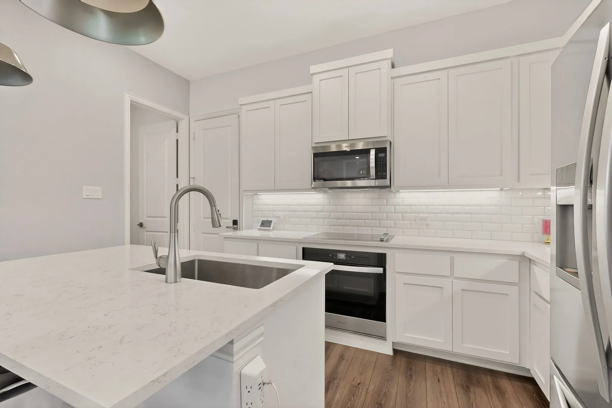Modern kitchen with white cabinets, stainless steel appliances, and a kitchen island with sink