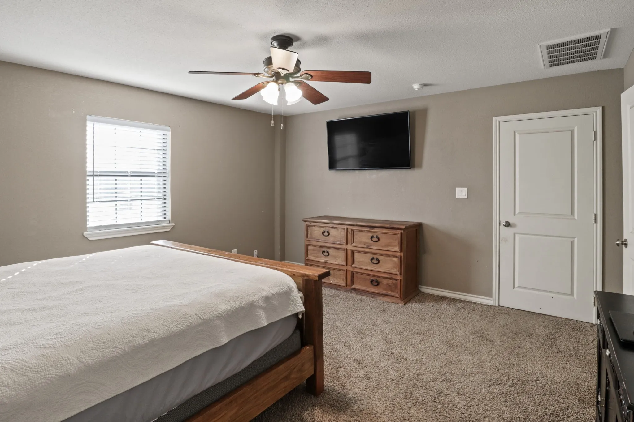 First Primary Bedroom Carpeted interior room featuring neutral wall tones and a ceiling fan with light fixture