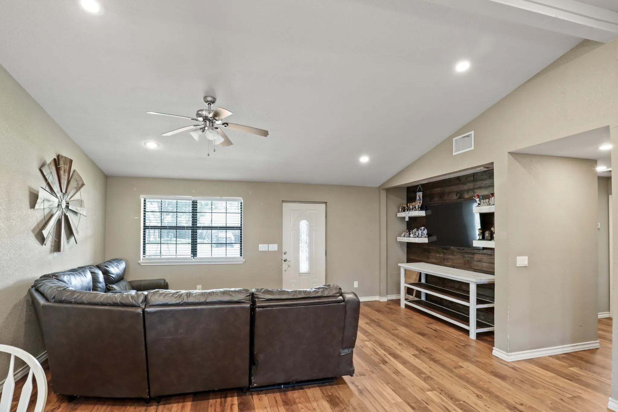 Living area featuring wood-finish flooring, a vaulted ceiling, and recessed lighting