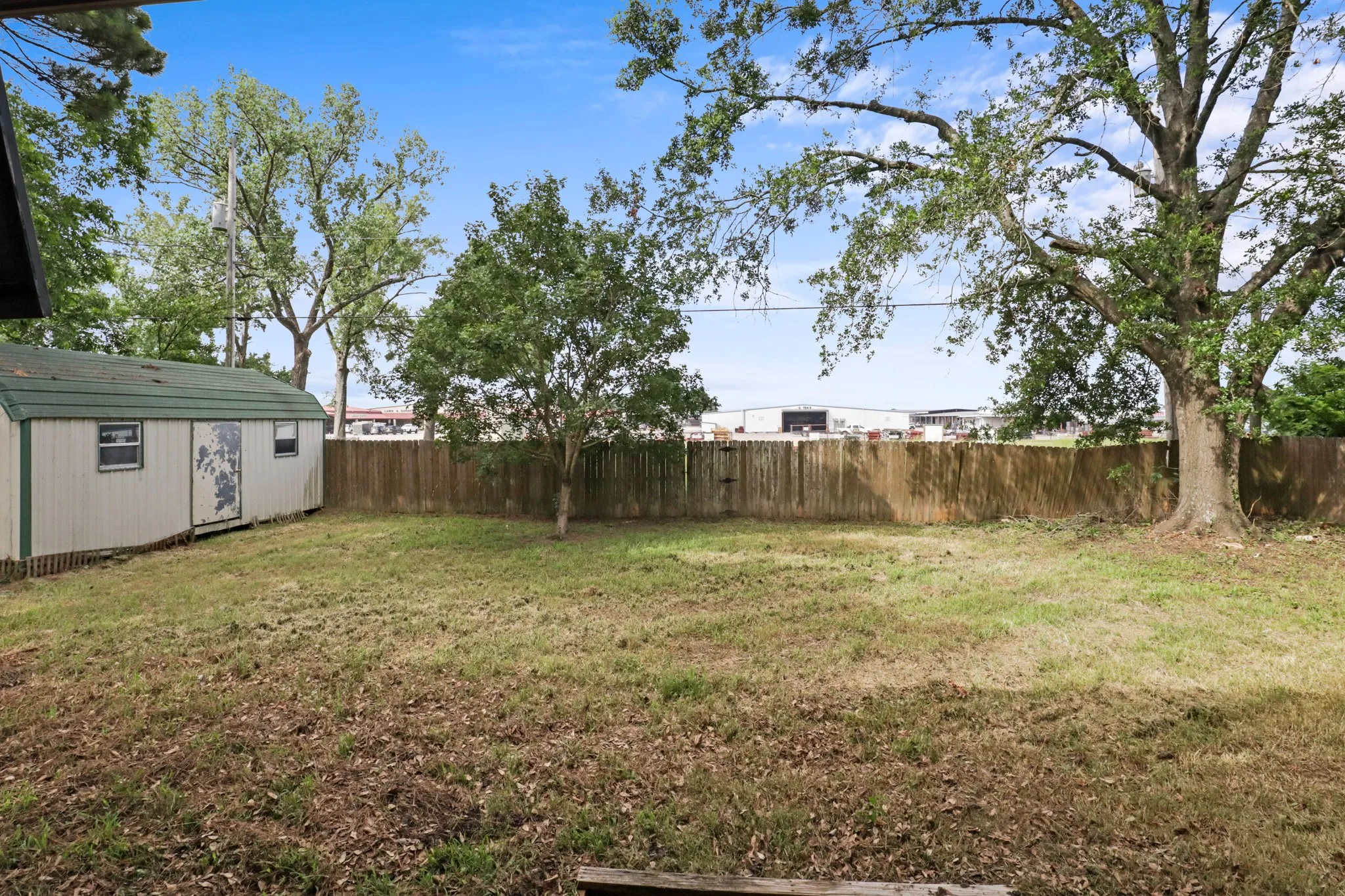 Backyard with a privacy fence and a large storage building

