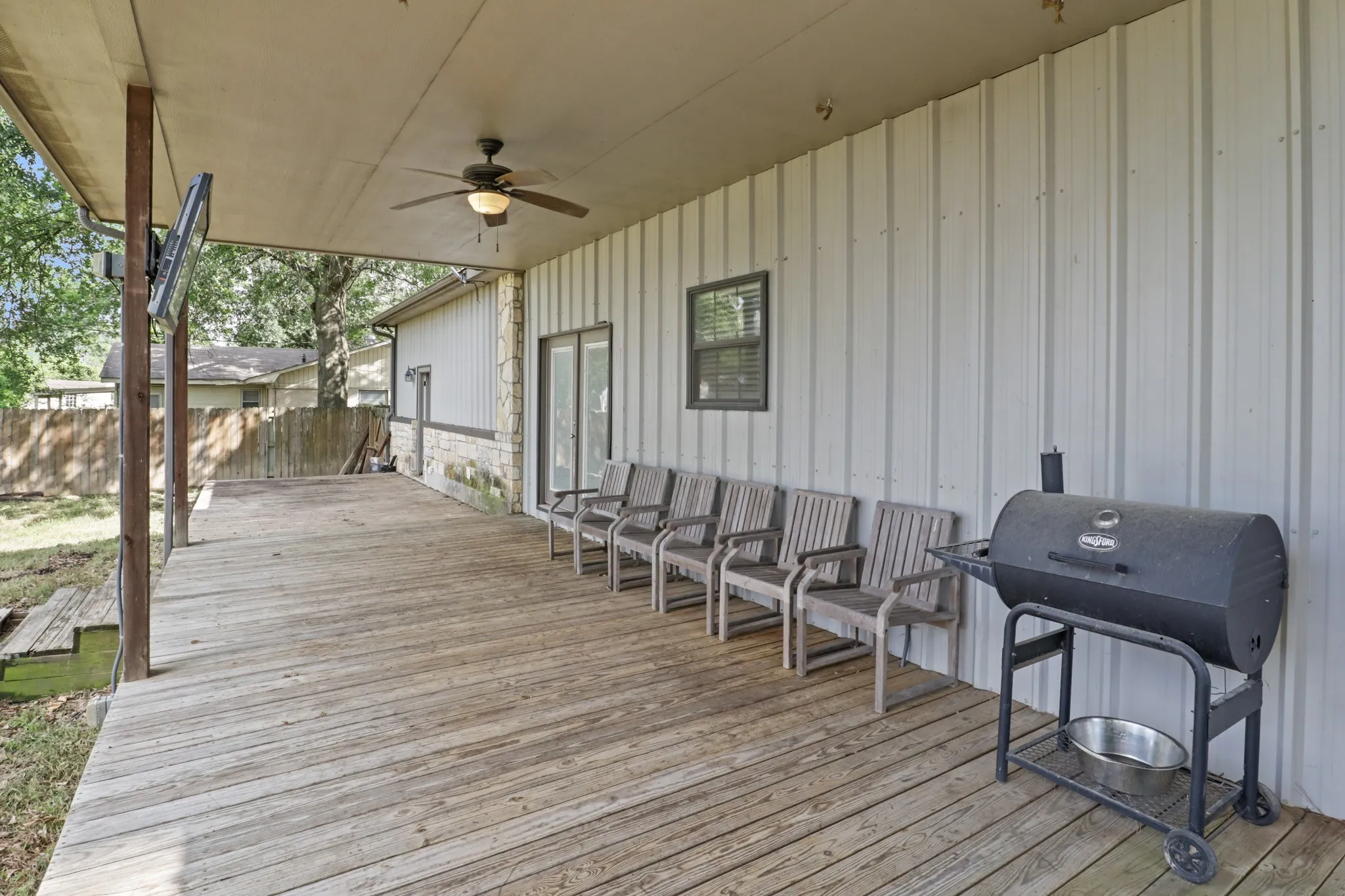 Expansive covered wood-finish deck with ceiling fan and integrated lighting
