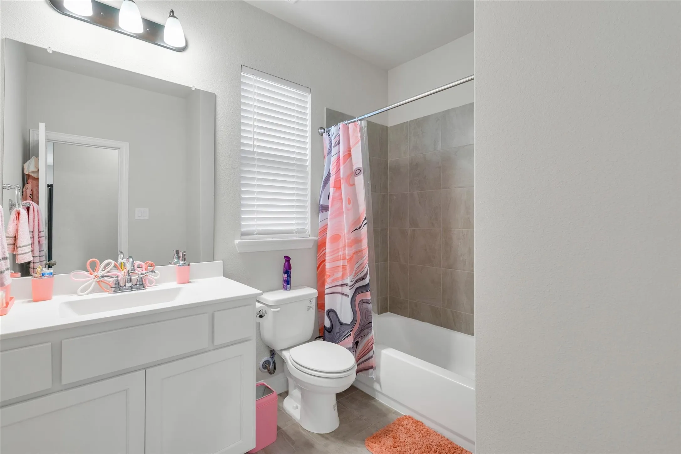 Bathroom featuring a white vanity with integrated sink, chrome faucet, and overhead three-bulb vanity light
