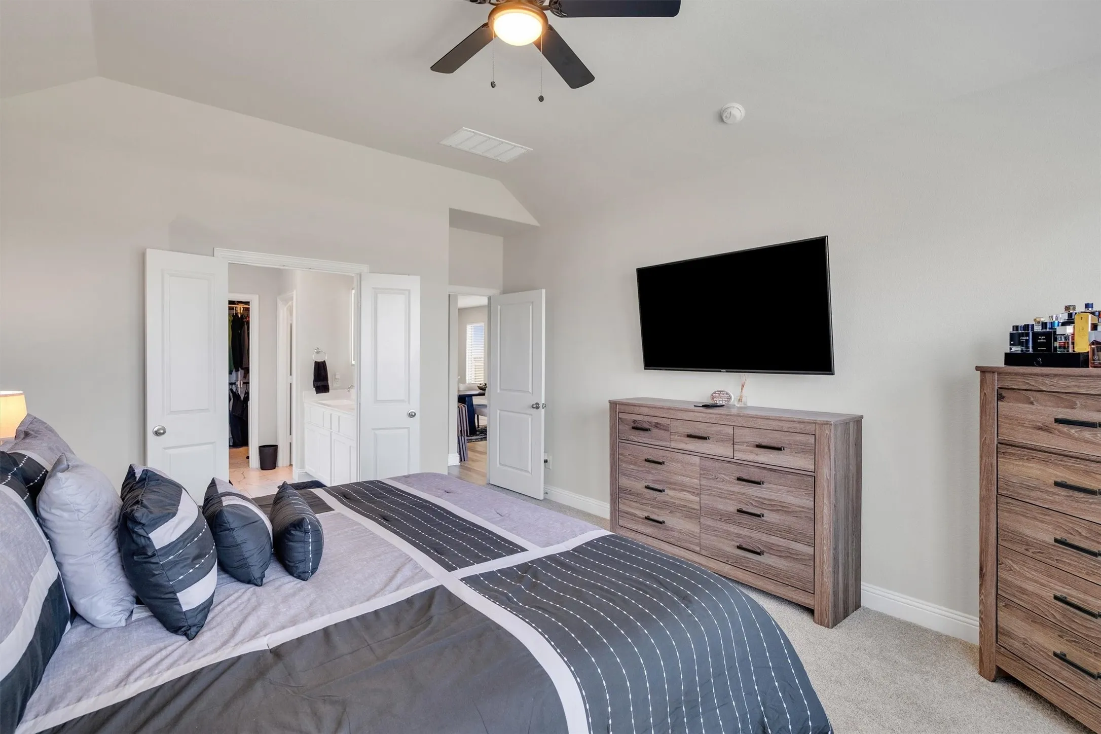 Carpeted sleeping area with light-toned walls and a ceiling fan