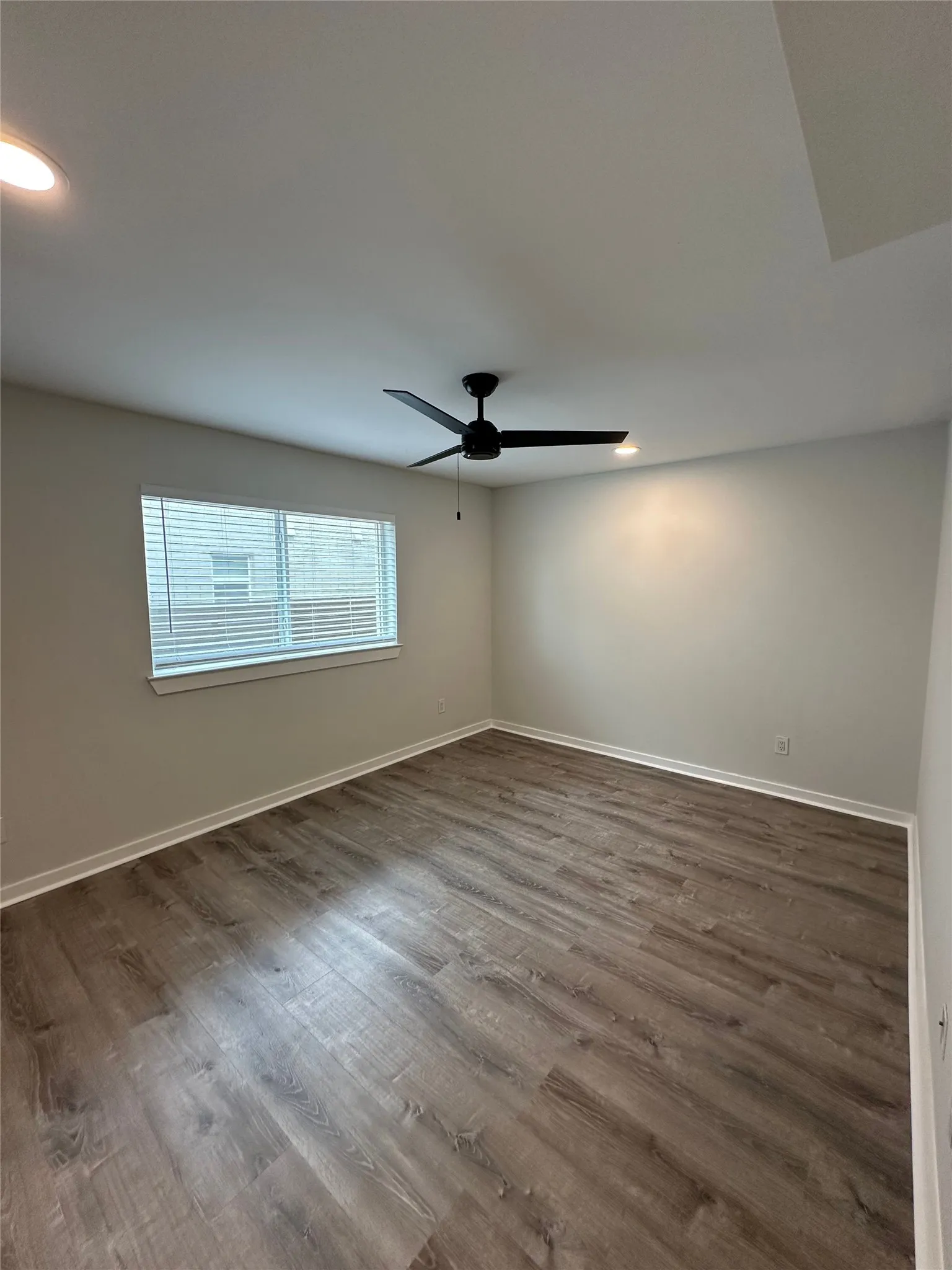 Neutral wall tones complement the wood-finish flooring
