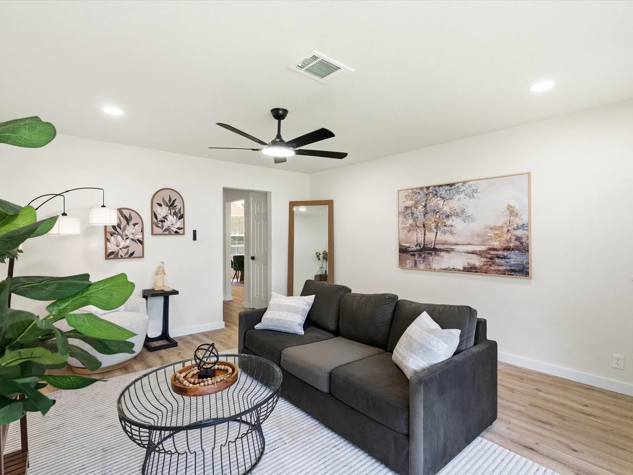 Living room features updated paint, ceiling fans, updated lighting, new floors and more! It is spacious for lots of furniture and very inviting.
