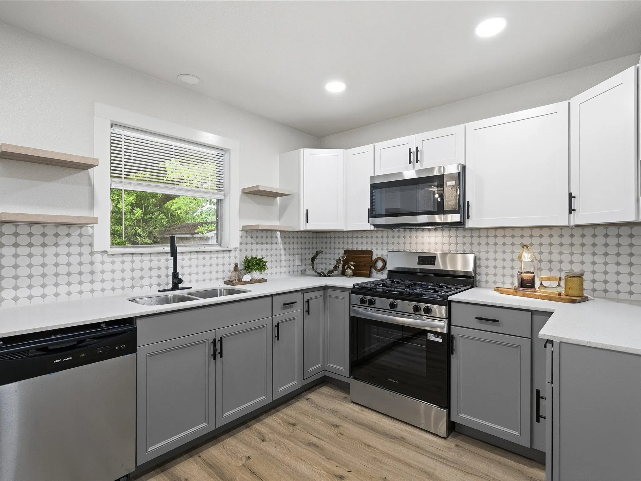 The kitchen features cute tile backsplash, floating shelves, updated cabinets, granite counters, ss appliances, new fixtures, new paint, updated lighting and more!