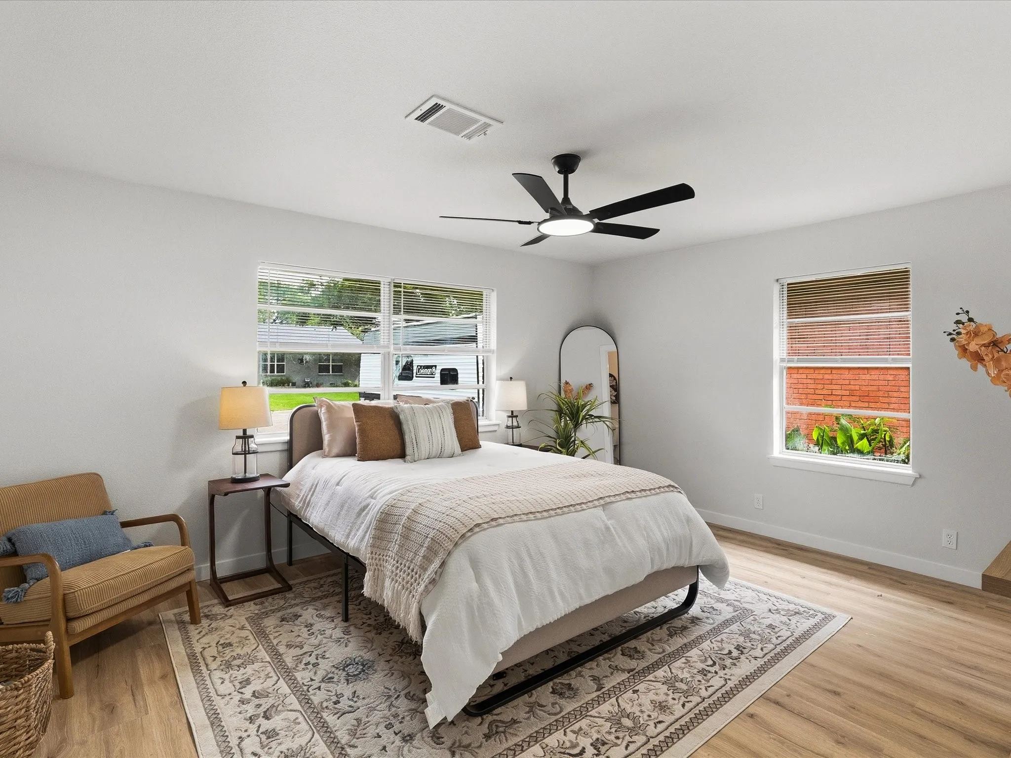 Primary bedroom features fresh paint, new floors, ceiling fan, multiple windows for natural light, an ensuite bathroom and more!