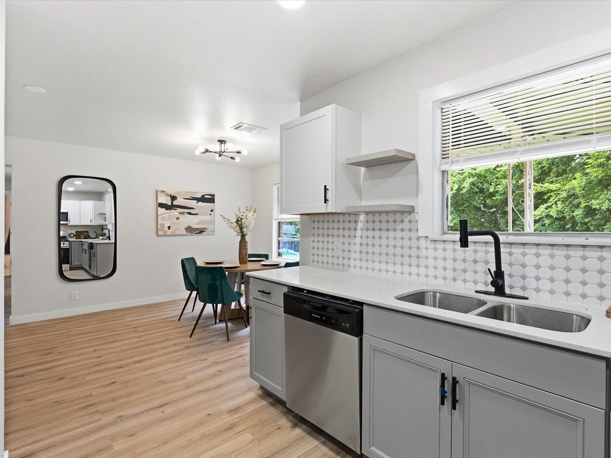 The kitchen features cute tile backsplash, floating shelves, updated cabinets, granite counters, ss appliances, new fixtures, new paint, updated lighting and more!