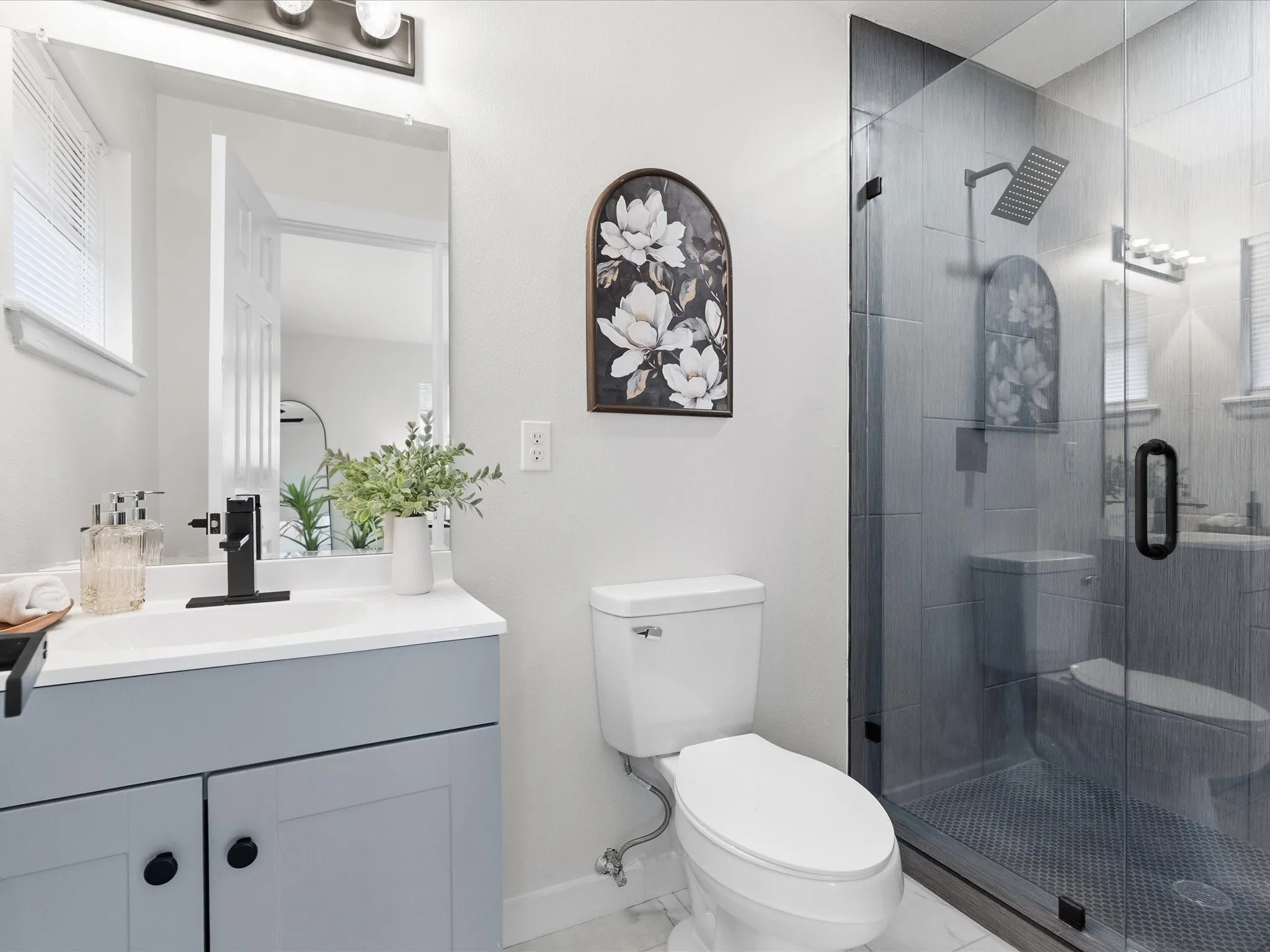Primary bathroom features new vanity, new paint, gorgeous title shower, updated fixtures, etc.