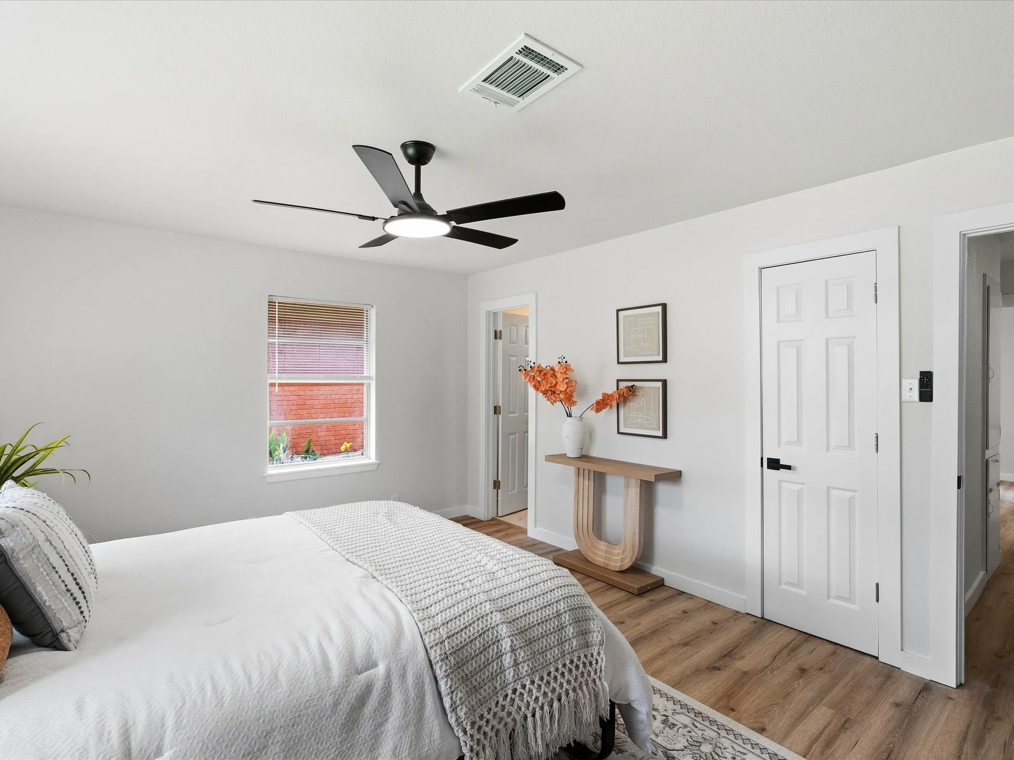 Primary bedroom features fresh paint, new floors, ceiling fan, multiple windows for natural light, an ensuite bathroom and more!
