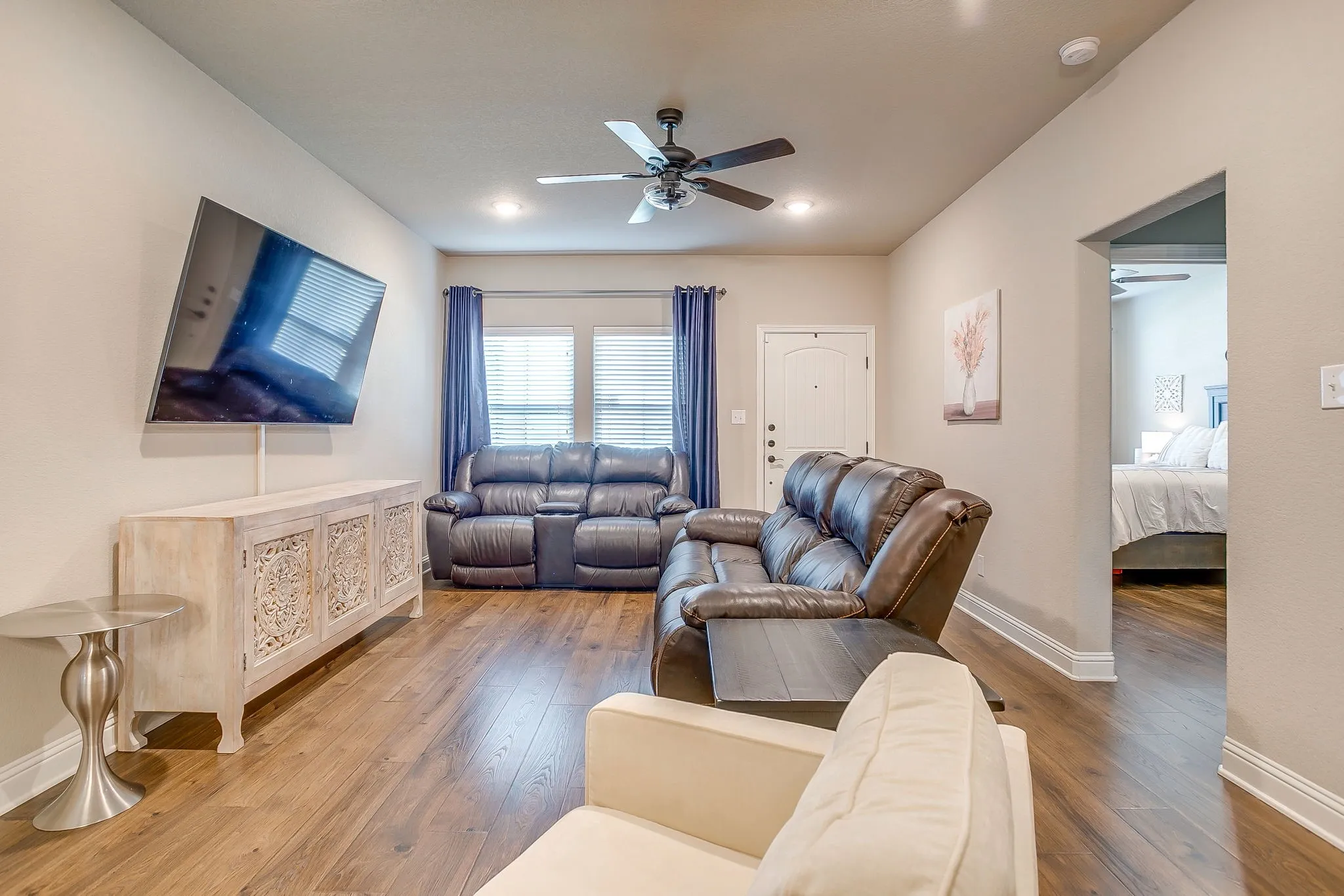 Living area featuring wood-finish flooring, neutral wall tones, and recessed lighting