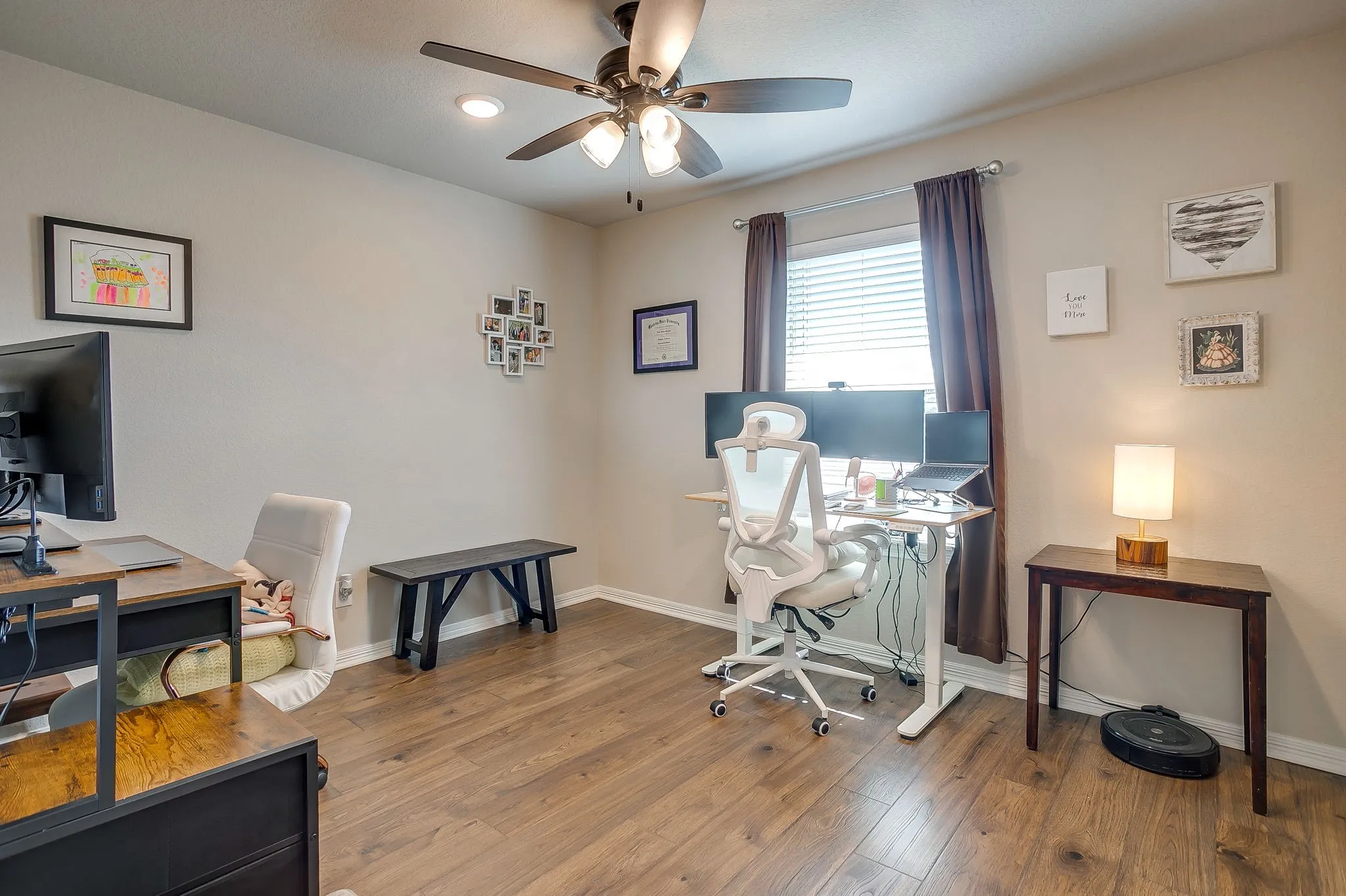 Interior room featuring wood-finish flooring, neutral wall paint, and a ceiling fan with integrated lighting