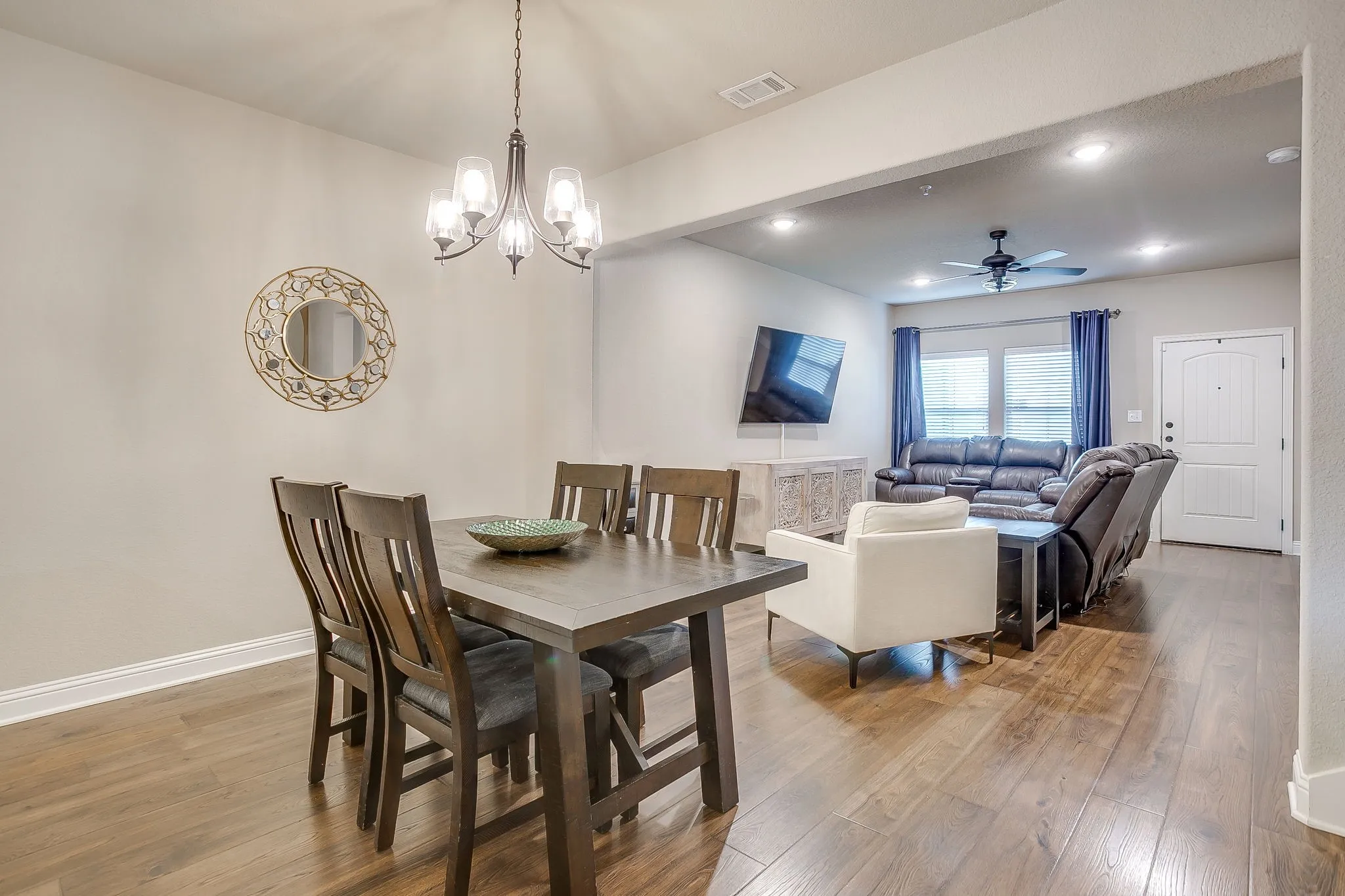 Open-concept living space featuring wood-finish flooring, recessed lighting, and a contemporary chandelier