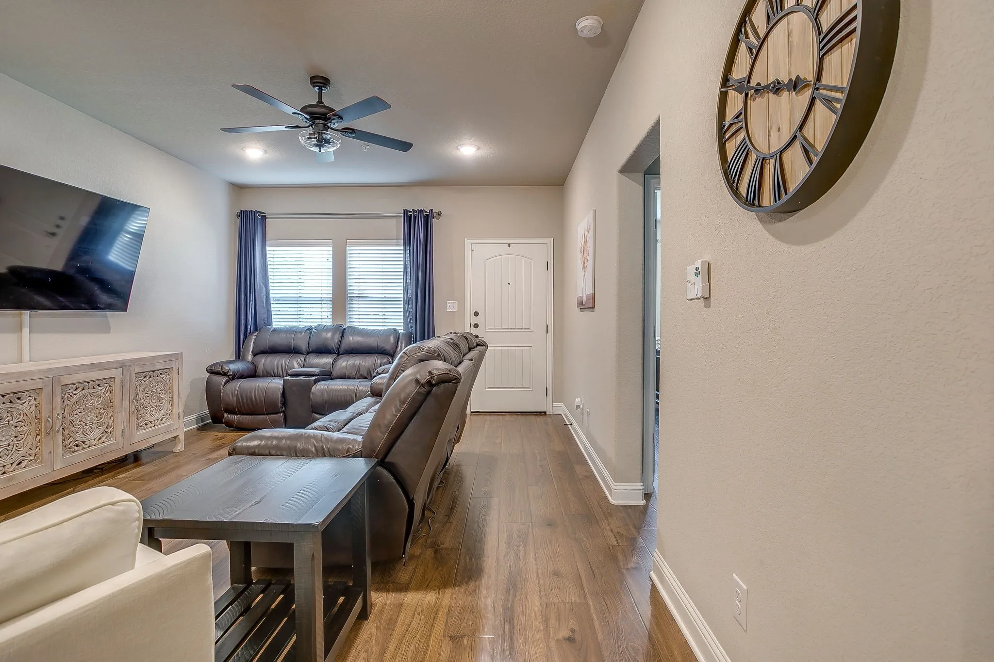 Spacious living area featuring wood-finish flooring, recessed lighting, and a ceiling fan