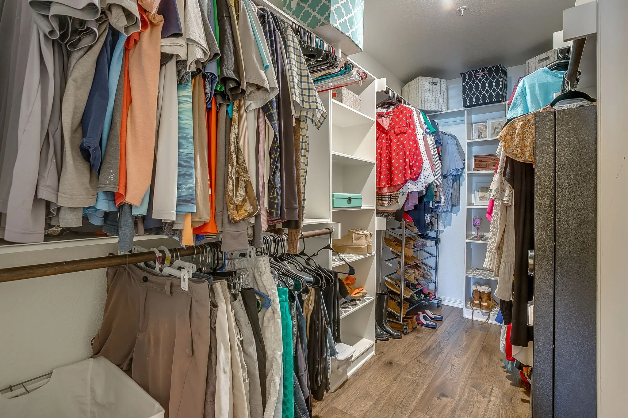 Walk-in closet featuring wood-finish flooring, recessed lighting, multiple hanging rods, built-in shelving, and dedicated shoe storage