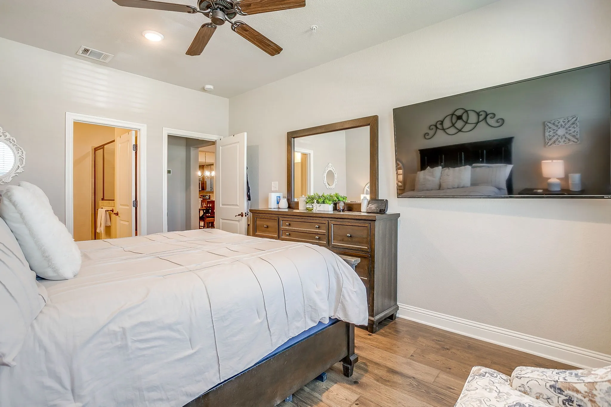 Bedroom featuring wood-finish flooring, a ceiling fan with light fixture, and crown molding