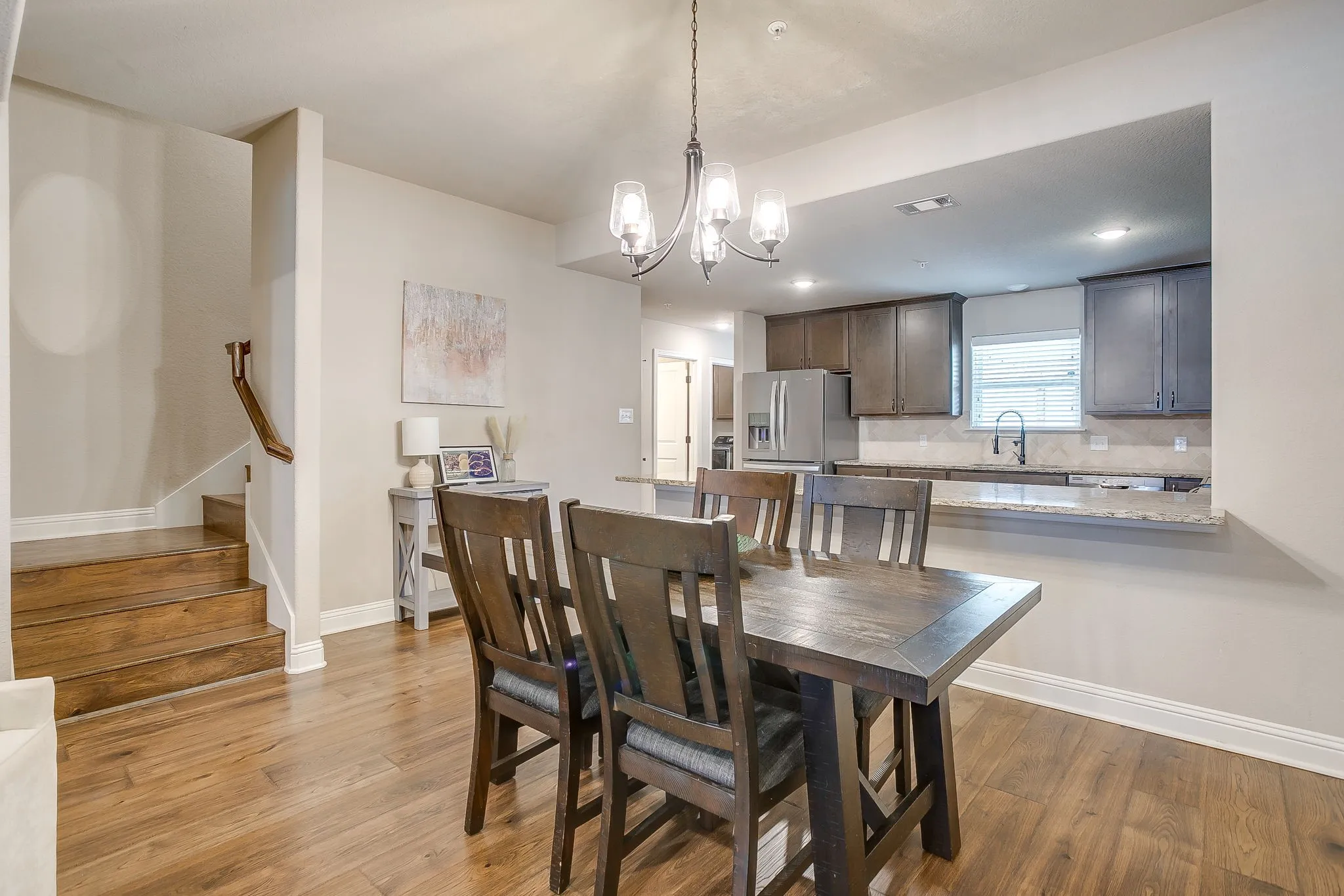 Dining area featuring a contemporary chandelier and wood-finish flooring