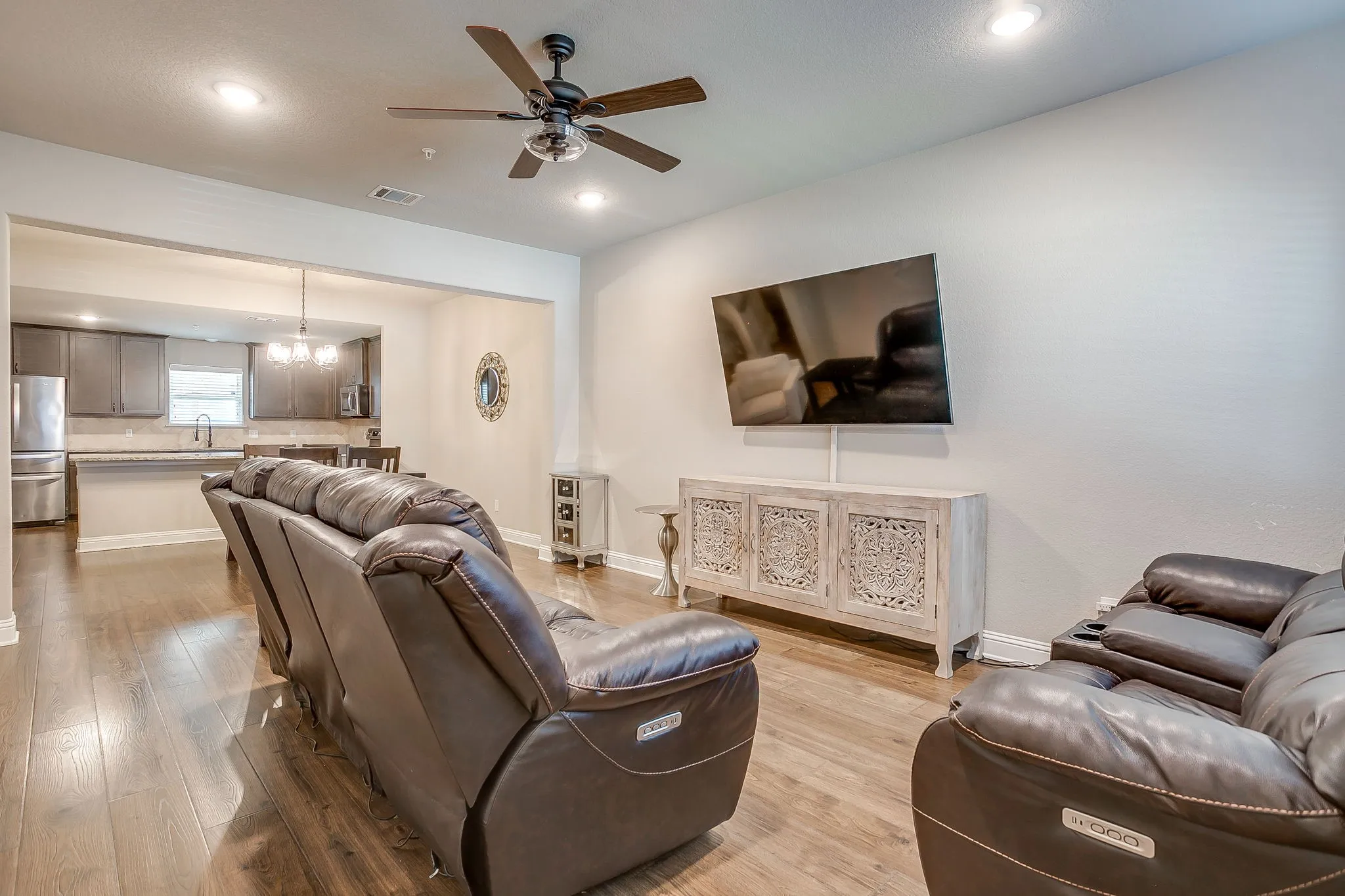 Open-concept living area featuring wood-finish flooring, recessed lighting, and a ceiling fan