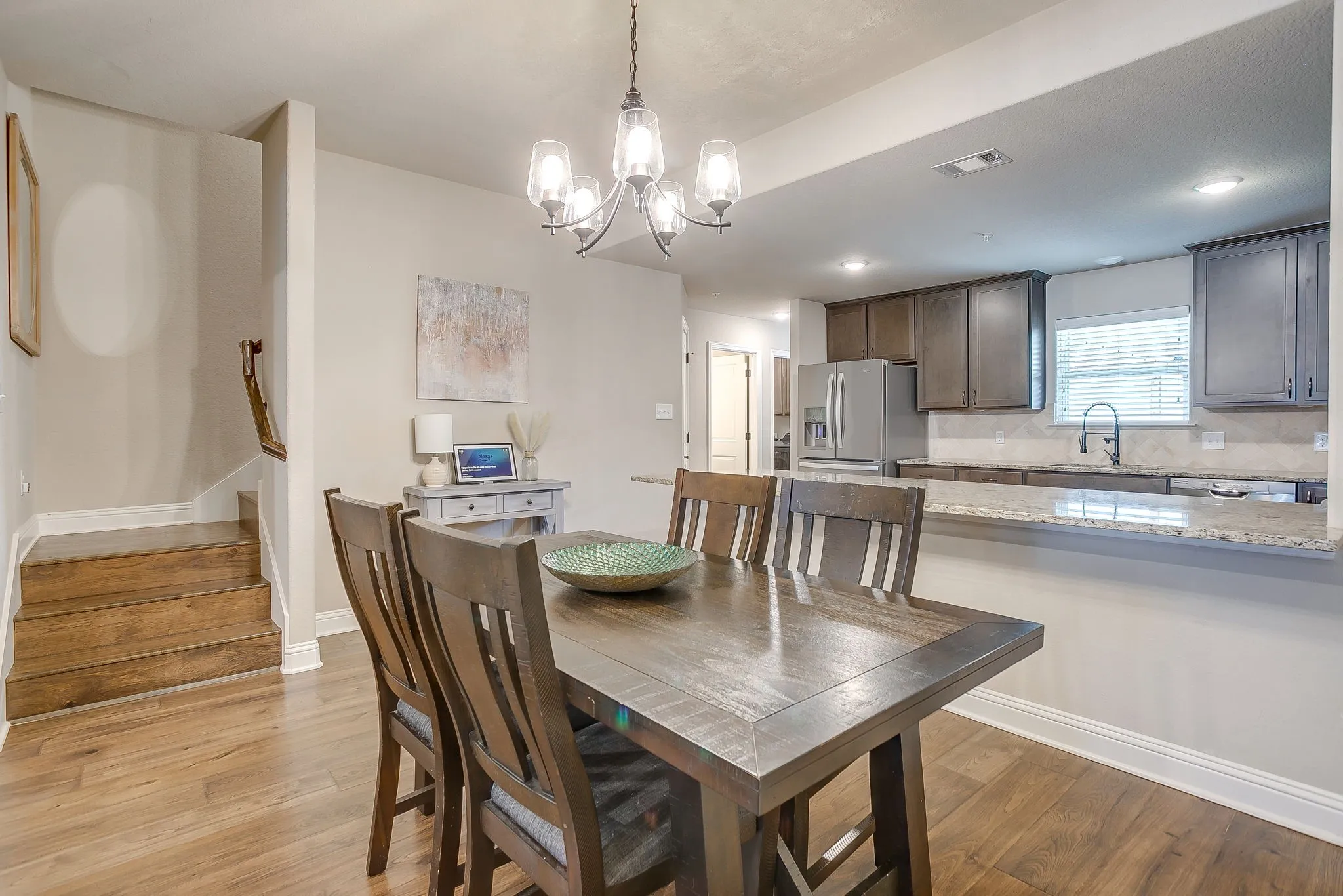 Dining area featuring wood-finish flooring and a contemporary chandelier