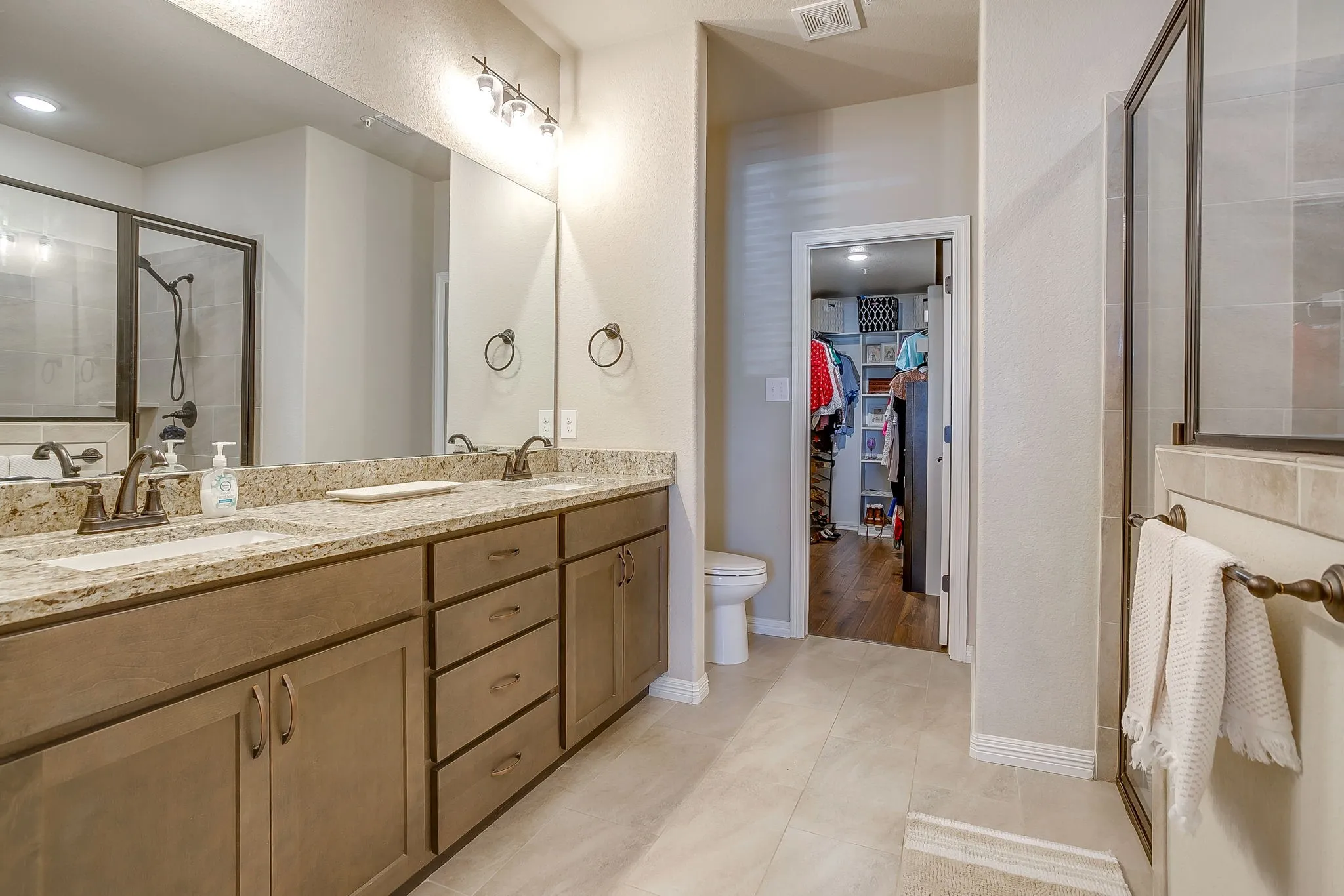 Spacious vanity with dual sinks, granite countertop, and ample cabinet storage