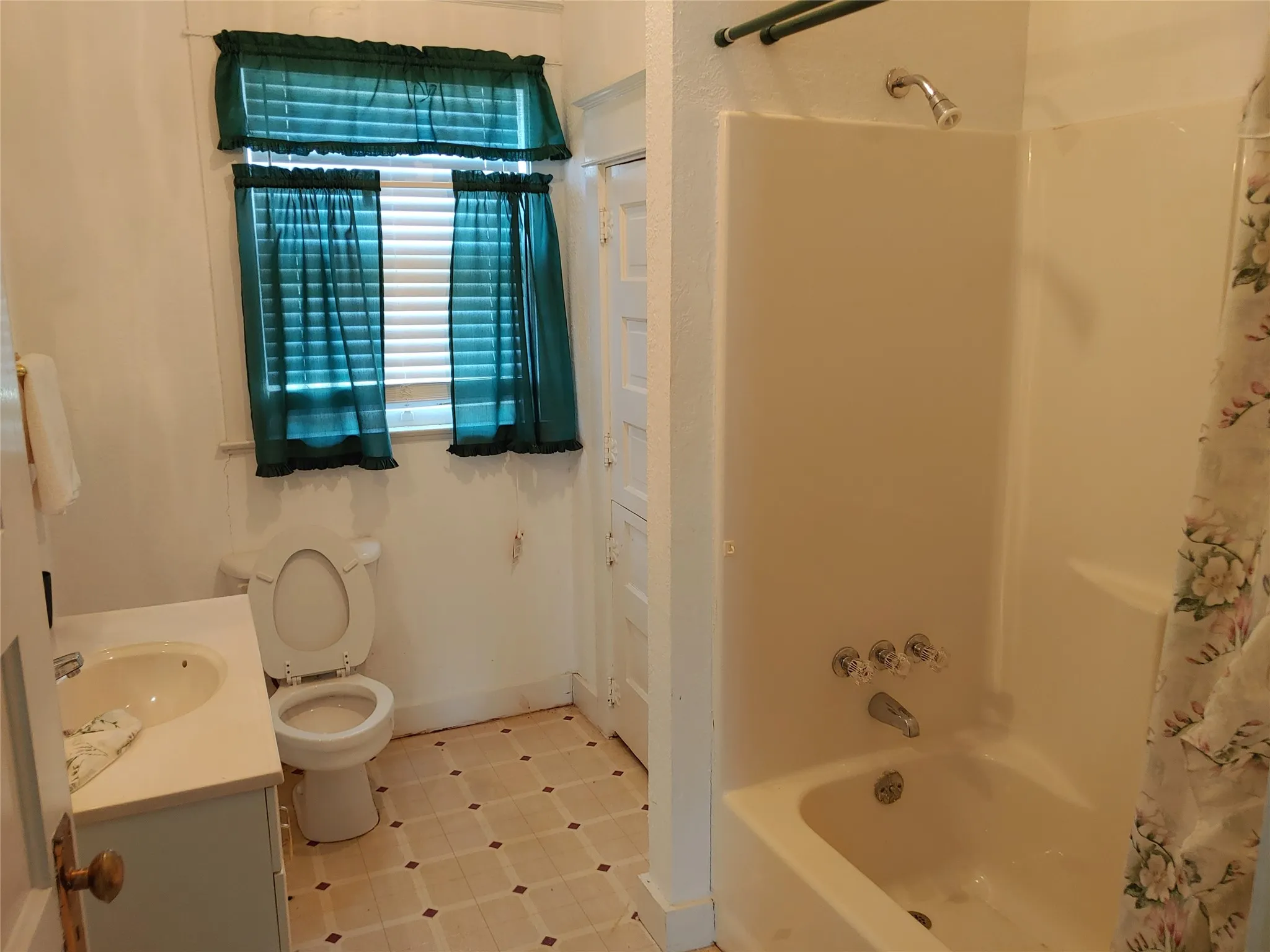 Upstairs guest bathroom featuring a white vanity with integrated sink, toilet, and a combined tub/shower unit