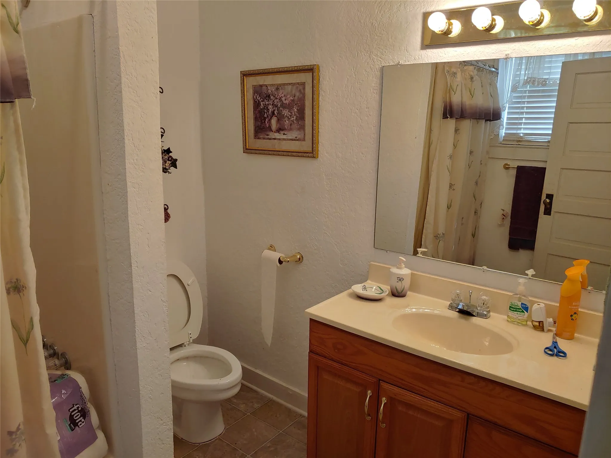 Bathroom featuring a vanity with a light-toned countertop, wood-finish cabinetry, and an integrated sink