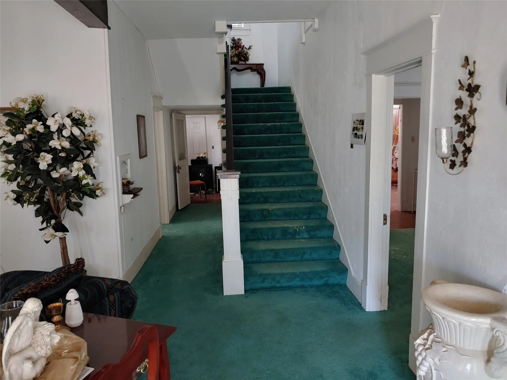 Interior entryway featuring a carpeted staircase with a white painted banister