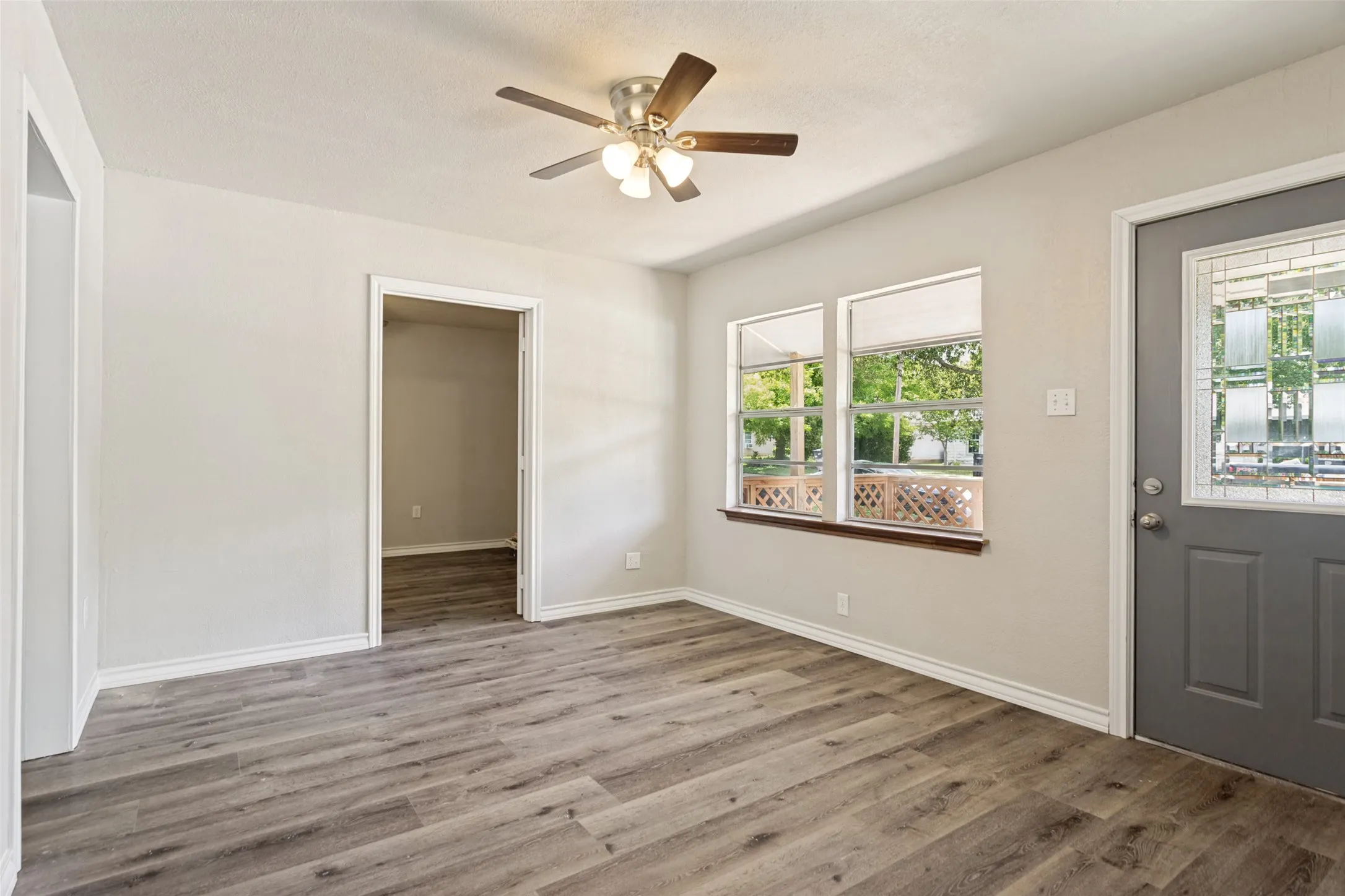 Bright room featuring wood-finish flooring, light neutral paint, and white trim