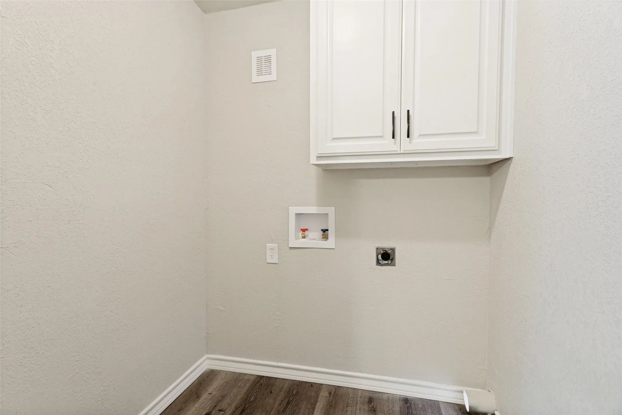 Utility area with wood-finish flooring and white baseboards