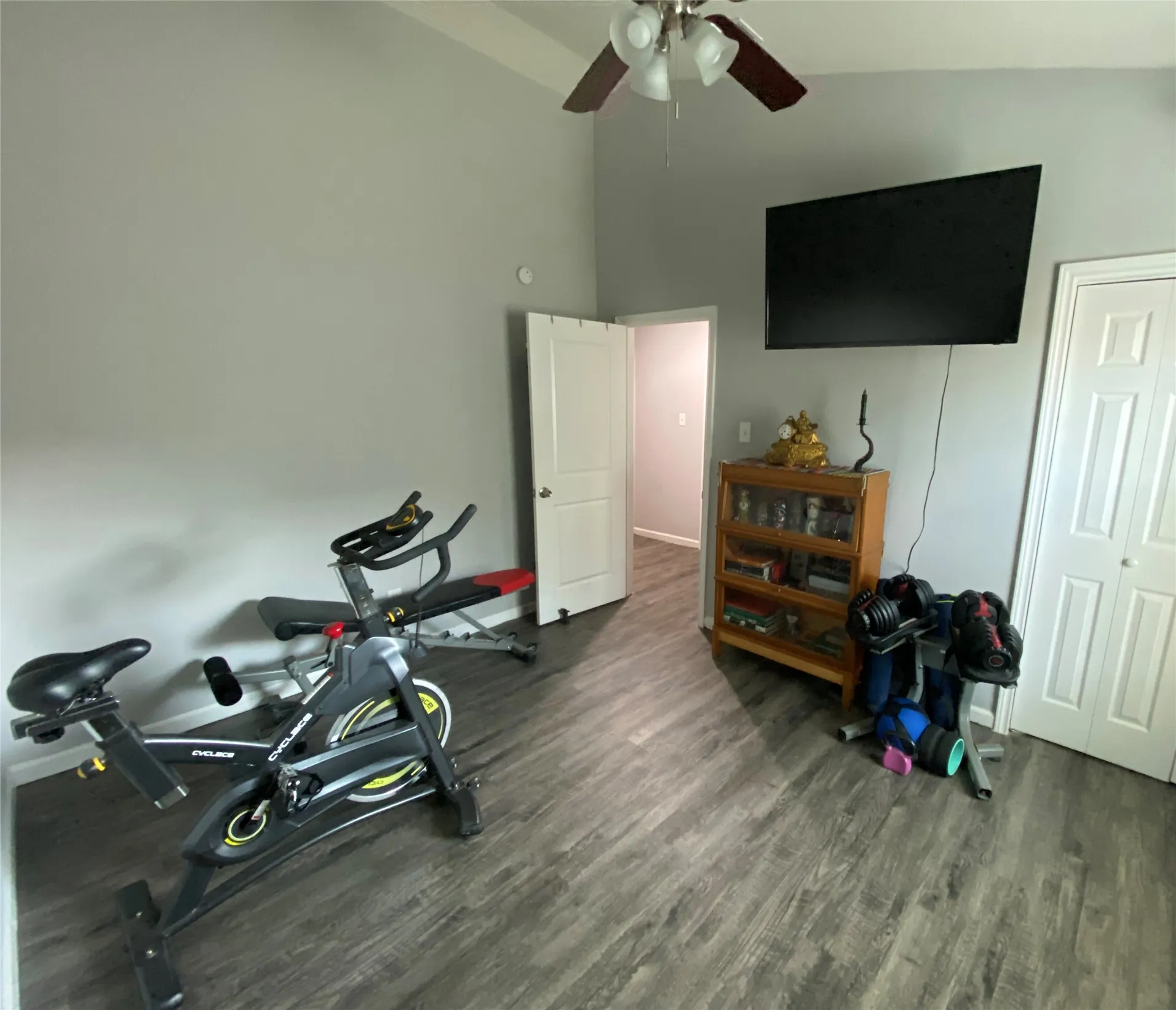 3rd bedroom being used as office-exercise room- featuring wood-finish flooring, vaulted ceiling, and a ceiling fan