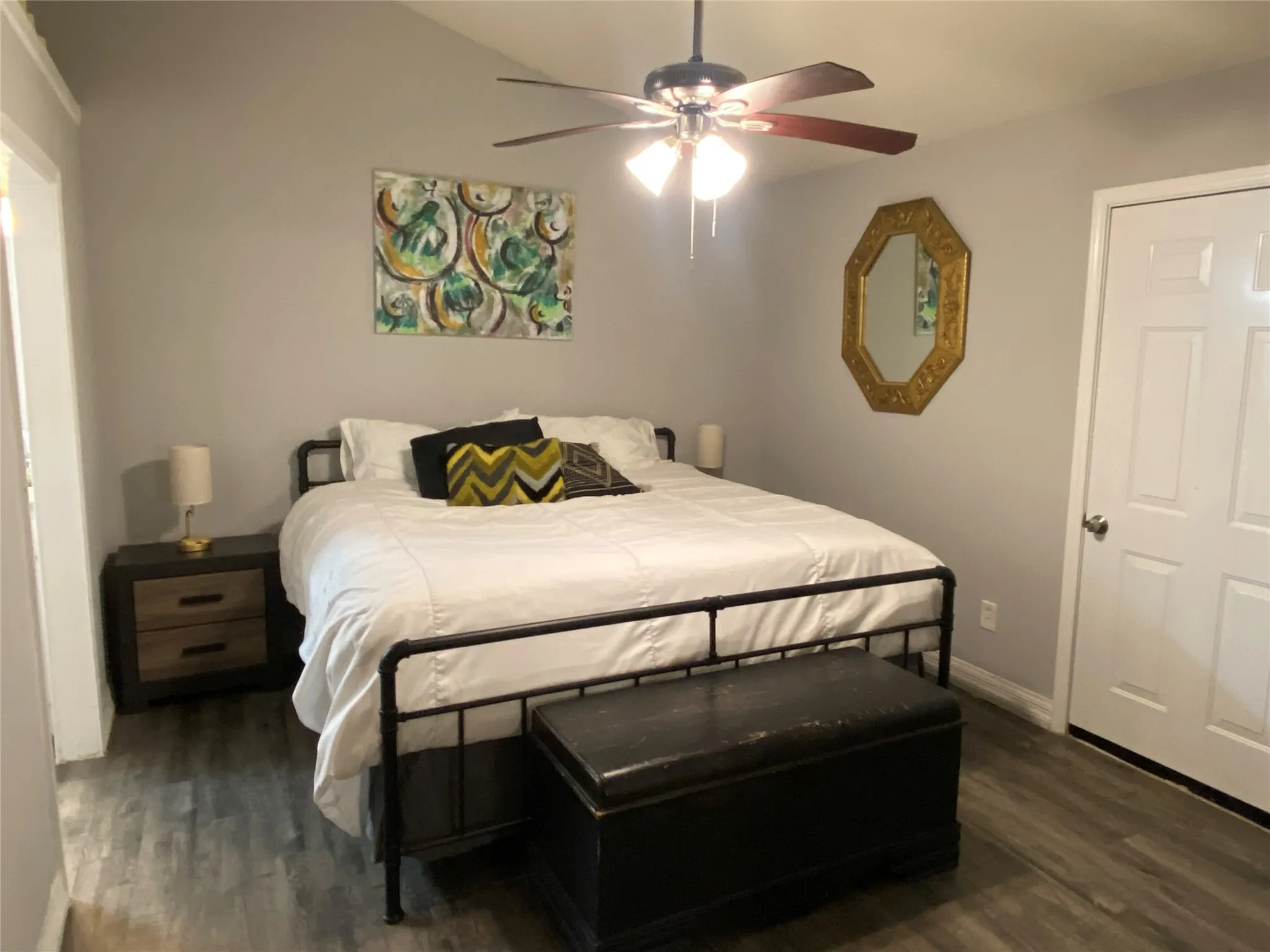 Bedroom featuring contiguous wood-finish flooring, a ceiling fan with integrated lighting and walk in closet