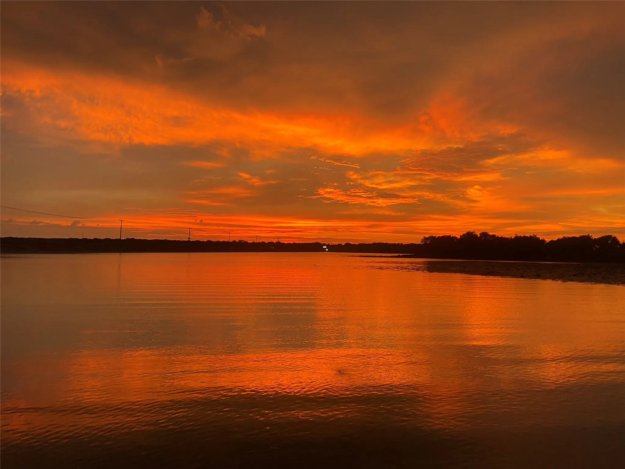 Waterfront expanse with vibrant sky scenery and distant treeline