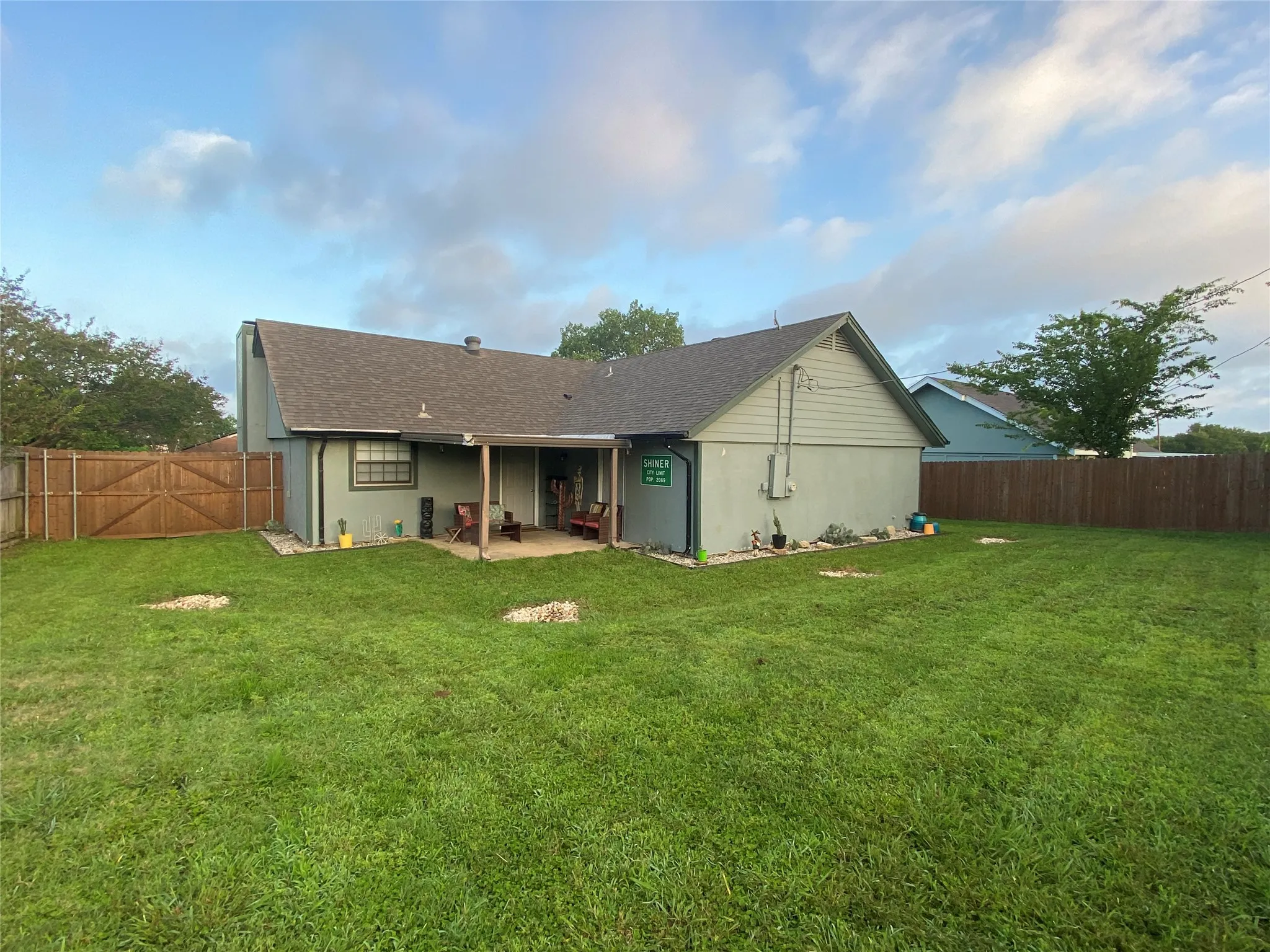 Covered patio, privacy fencing, and a generous lawn area