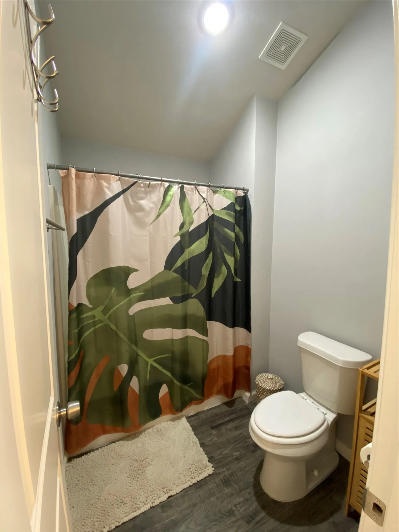 Primary bathroom with separate waterroom/shower area, featuring wood-finish flooring and recessed ceiling lighting with vaulted ceiling