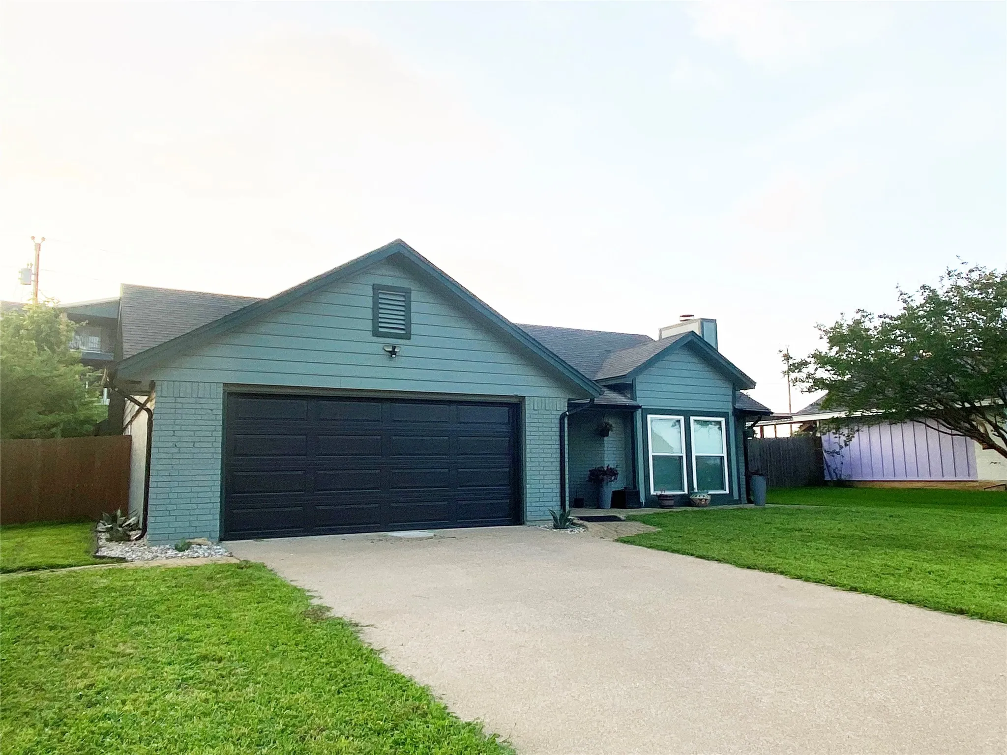 Exterior featuring a two-car garage and adorable from porch!