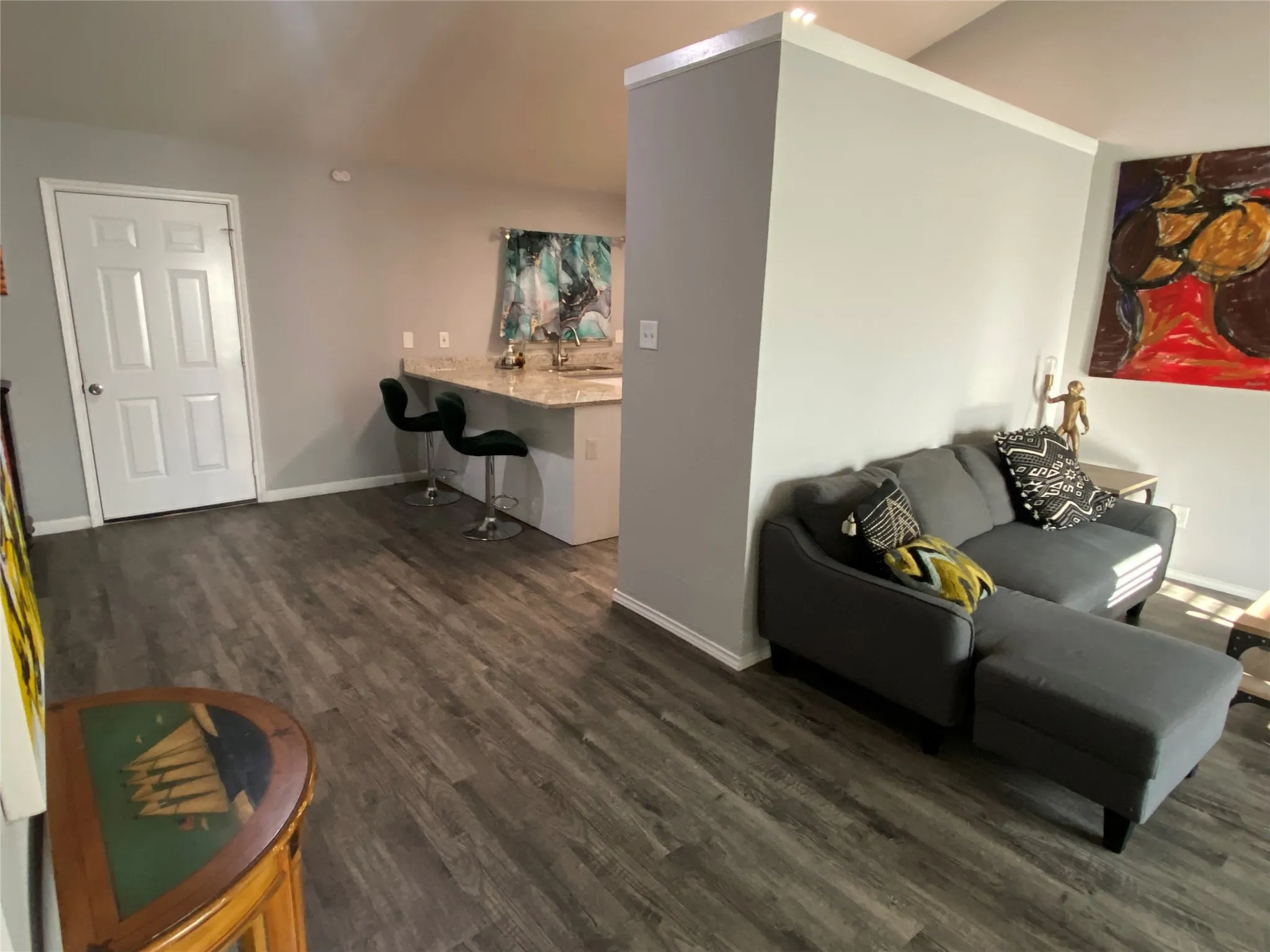 Open-concept living area featuring wood-finish flooring, light gray wall paint