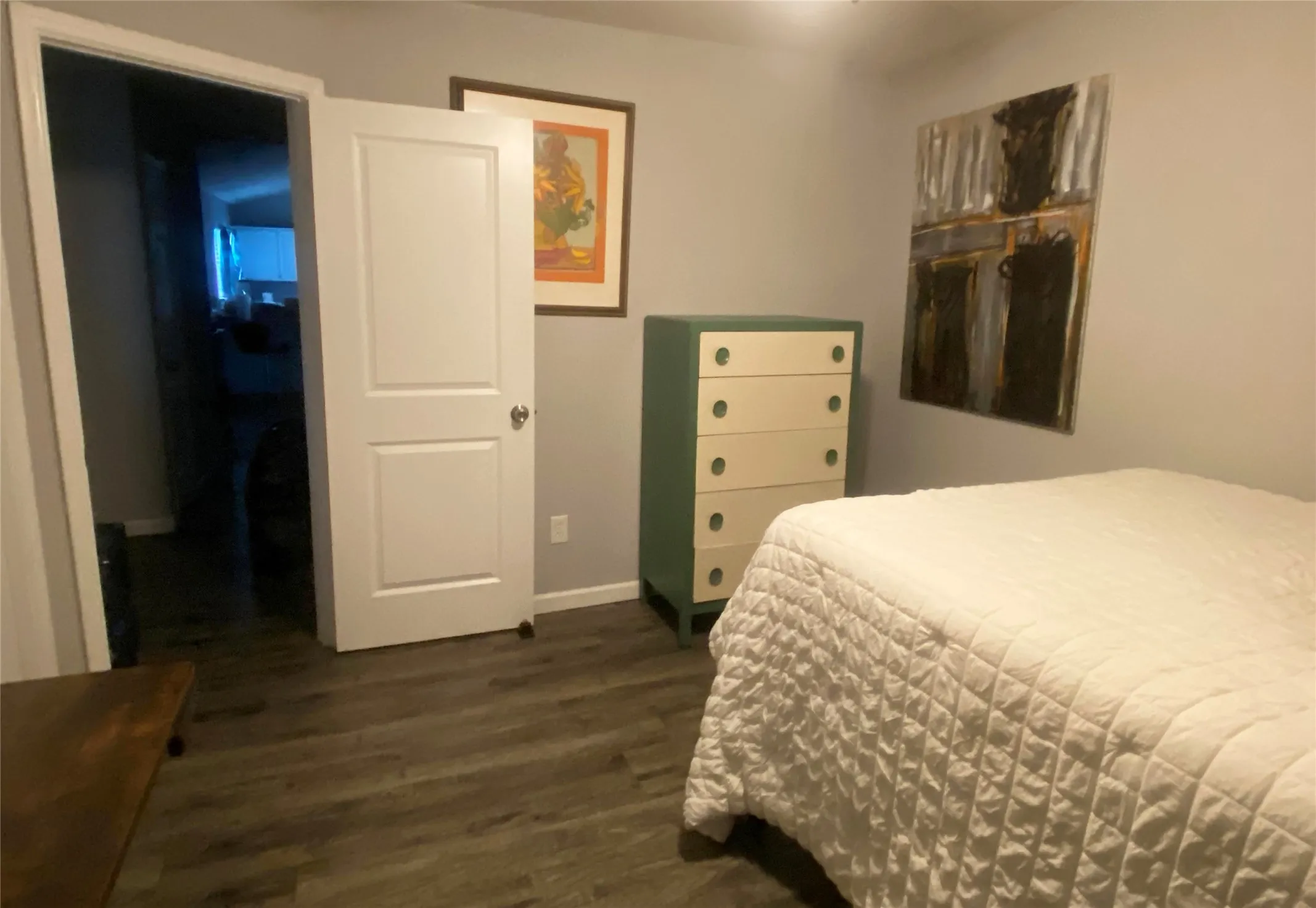 Guest bedroom has gray wood-finish flooring